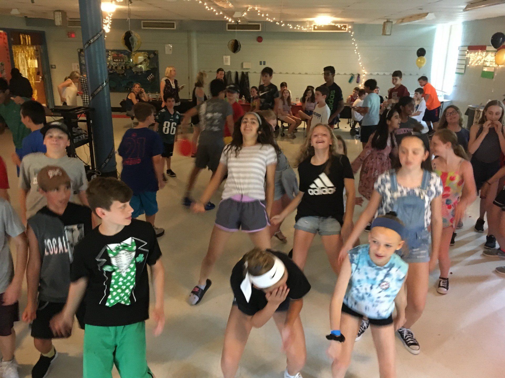 A group of children are dancing in a room.