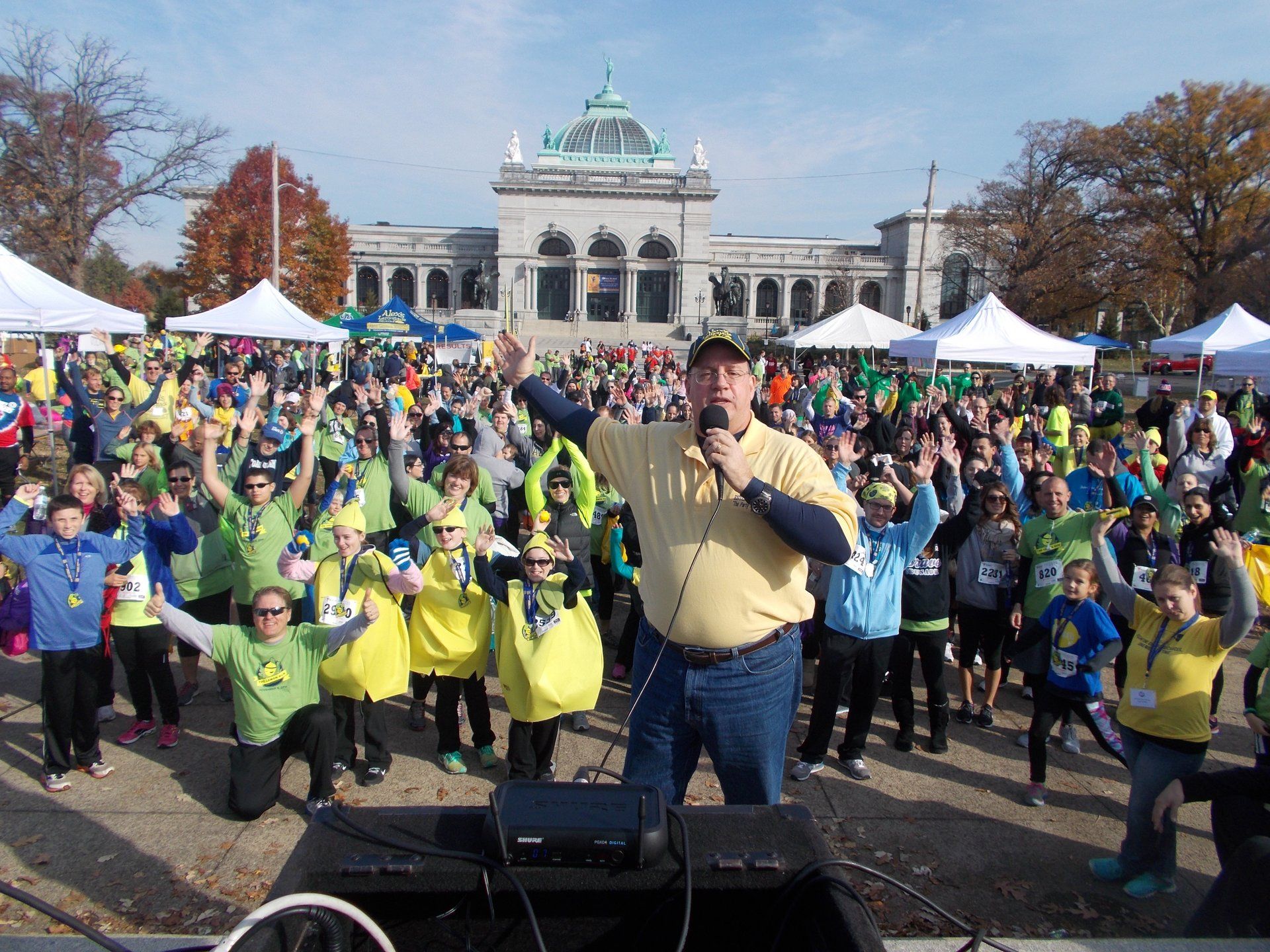 A man with a microphone stands in front of a crowd of people