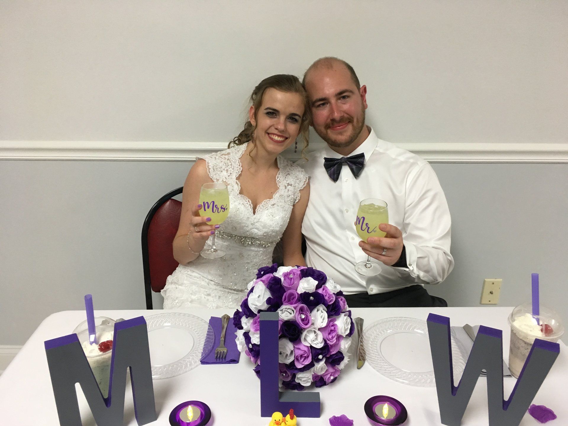 A bride and groom are posing for a picture at their wedding reception.