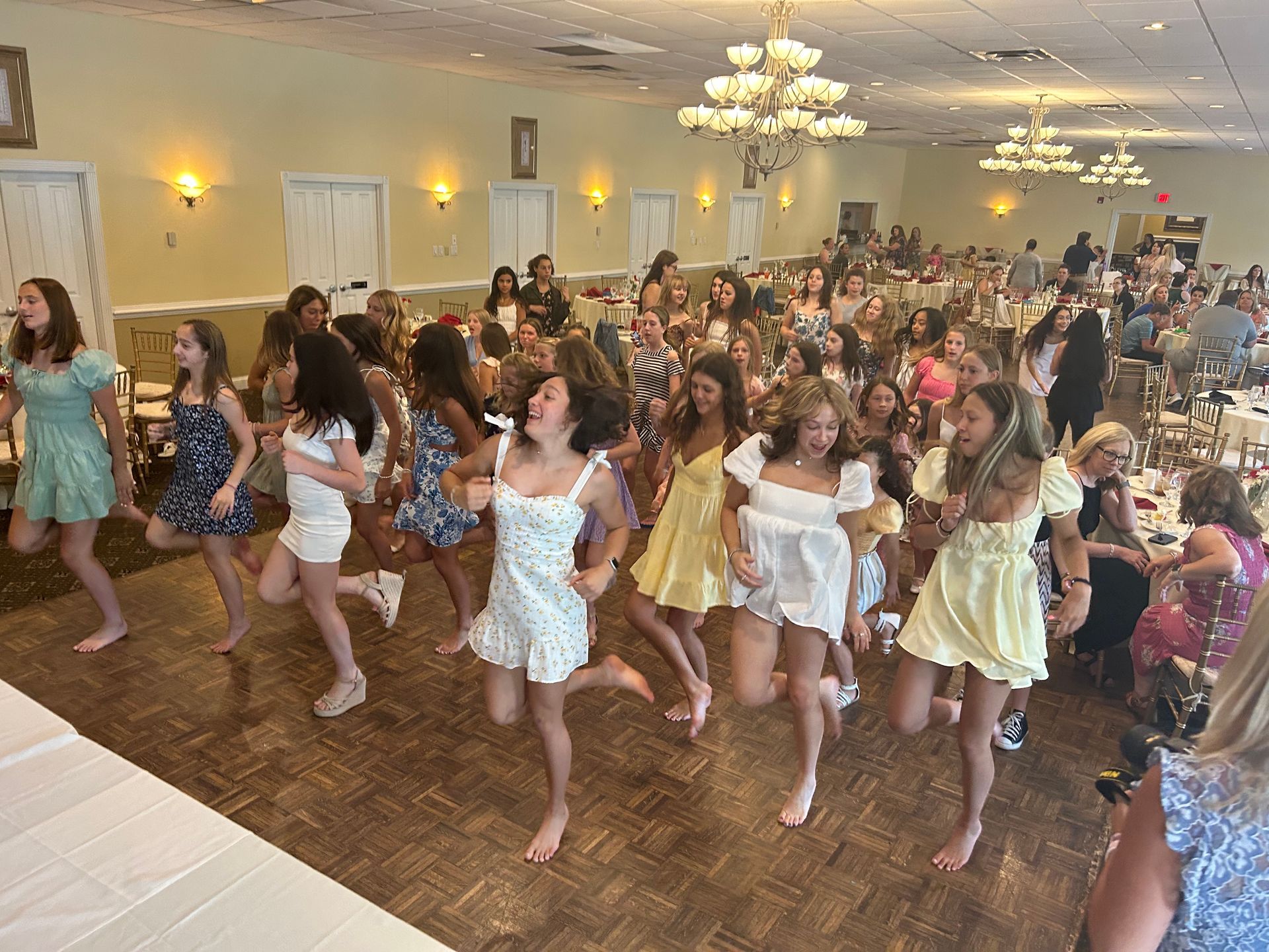 A large group of women are dancing in a large room.