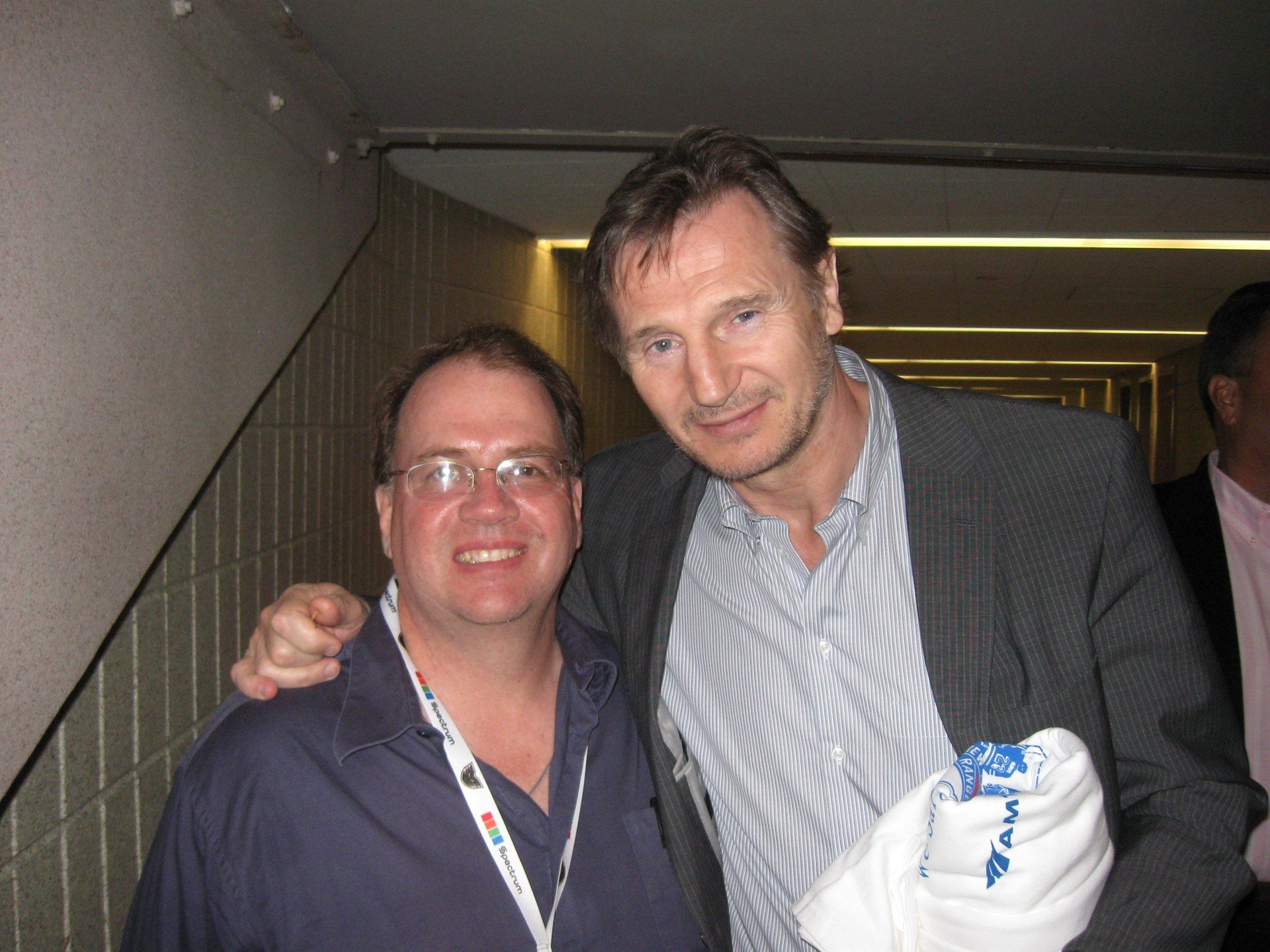 Two men are posing for a picture and one of them is holding a towel