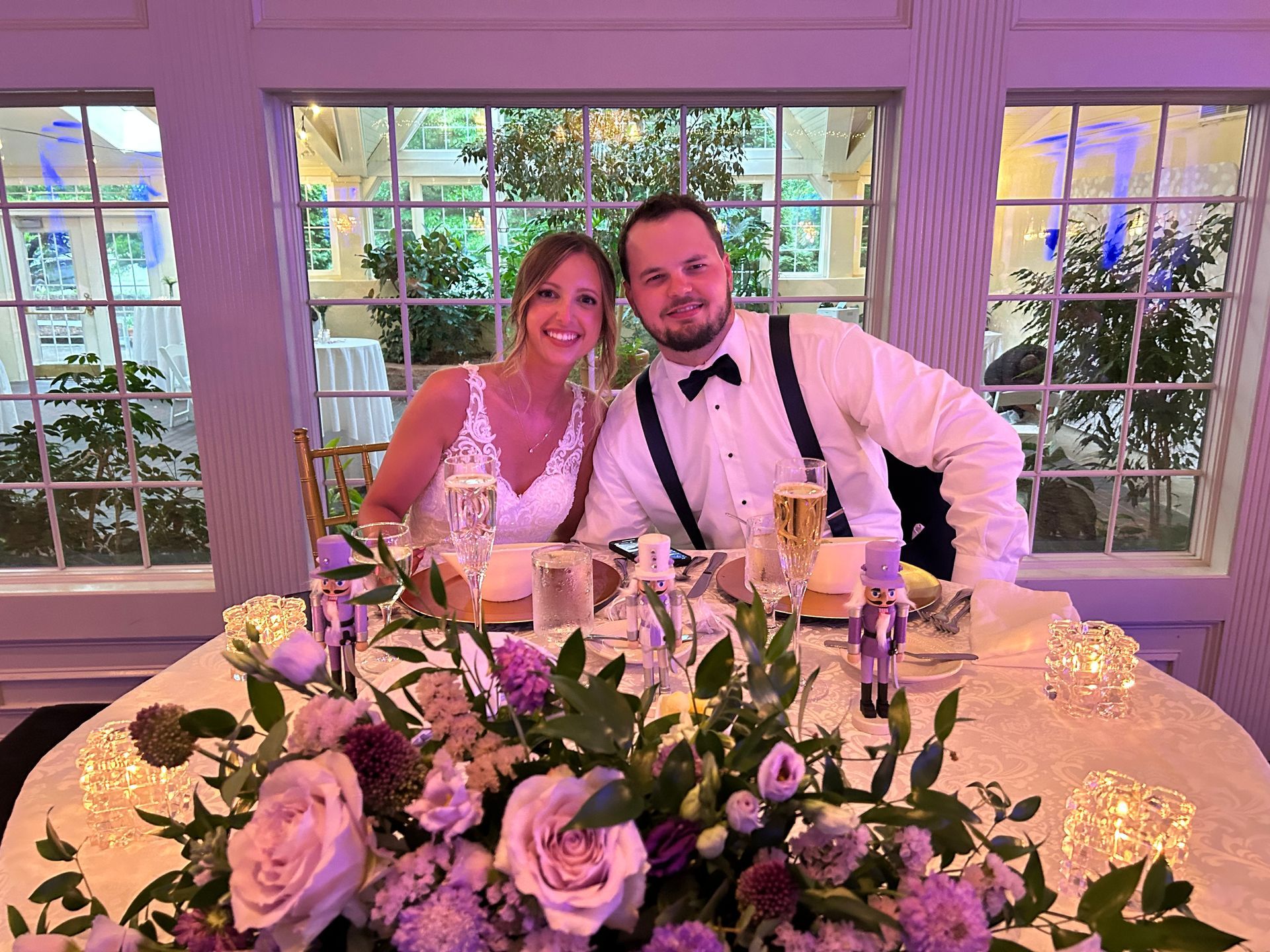 A bride and groom are posing for a picture at their wedding reception.