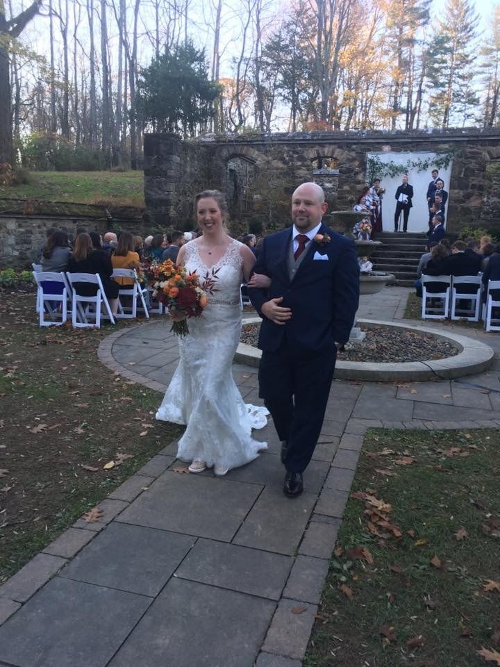 A bride and groom are walking down the aisle at their wedding.