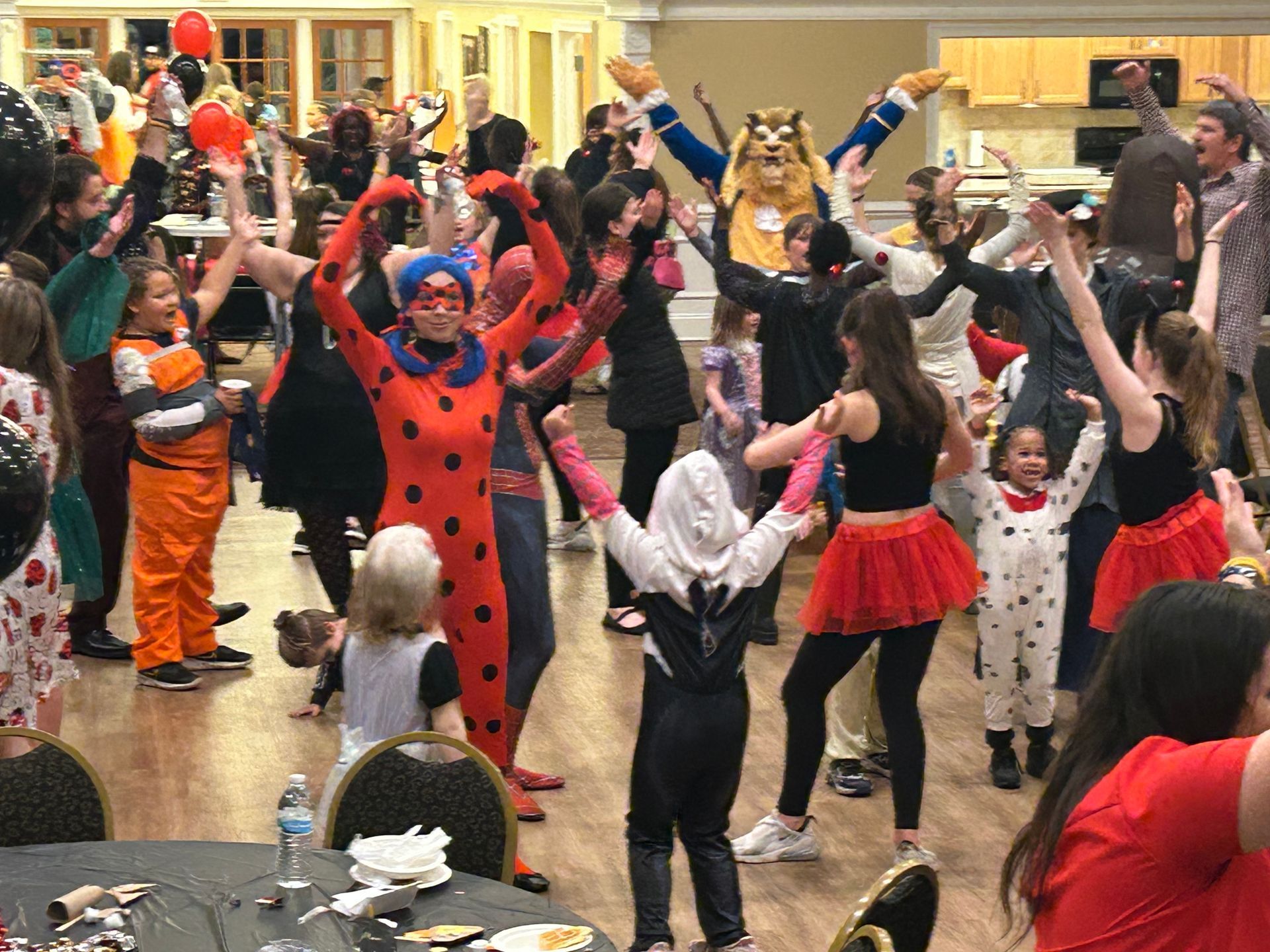 A group of people in costumes are dancing in a room.