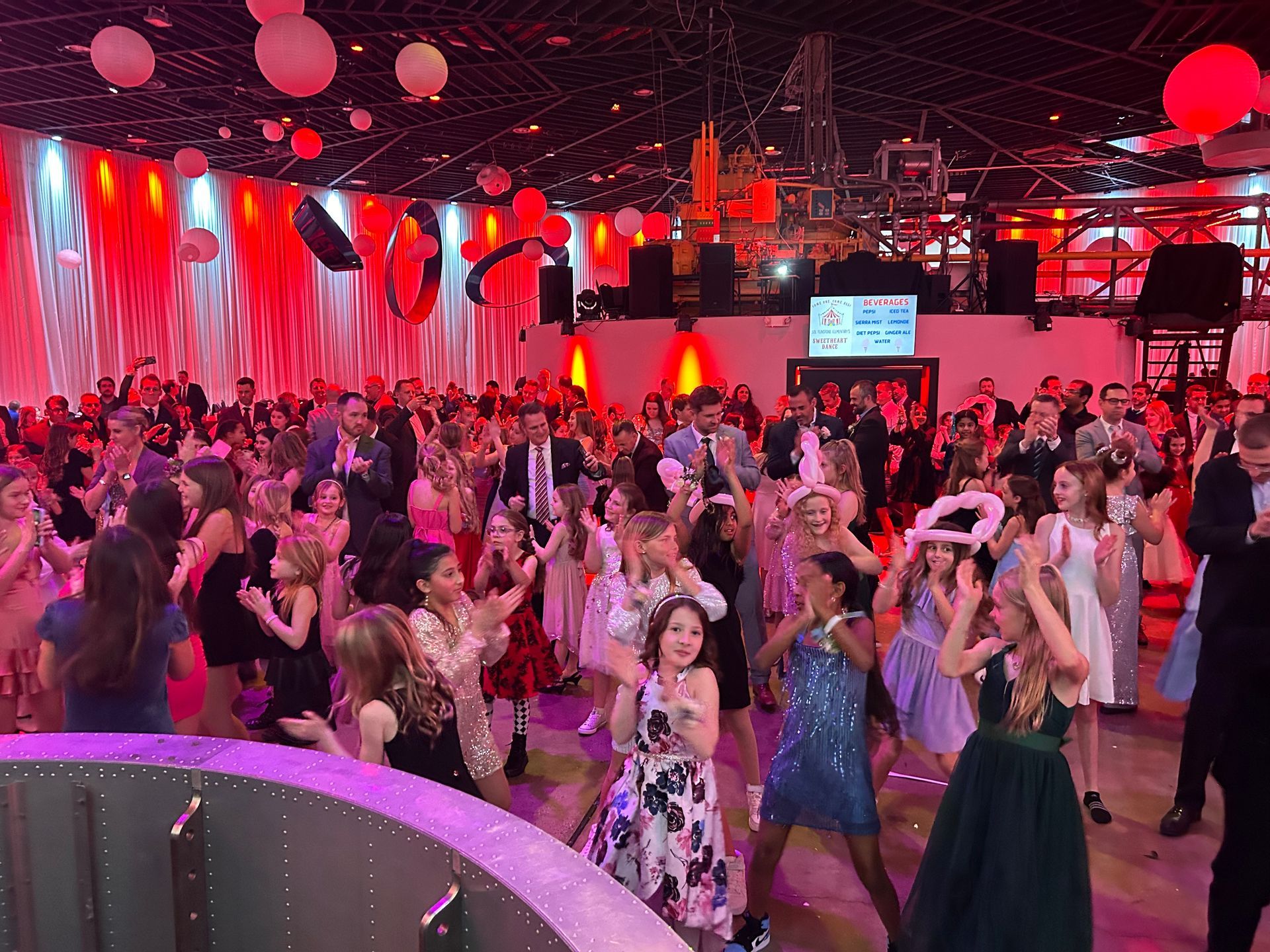 A large group of people are dancing in a large room.