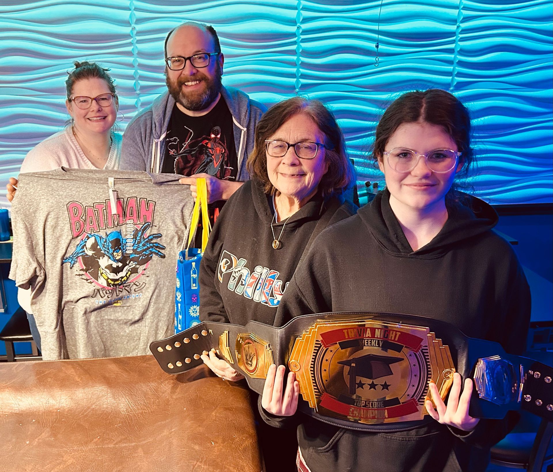 A group of people are posing for a picture while holding wrestling belts.
