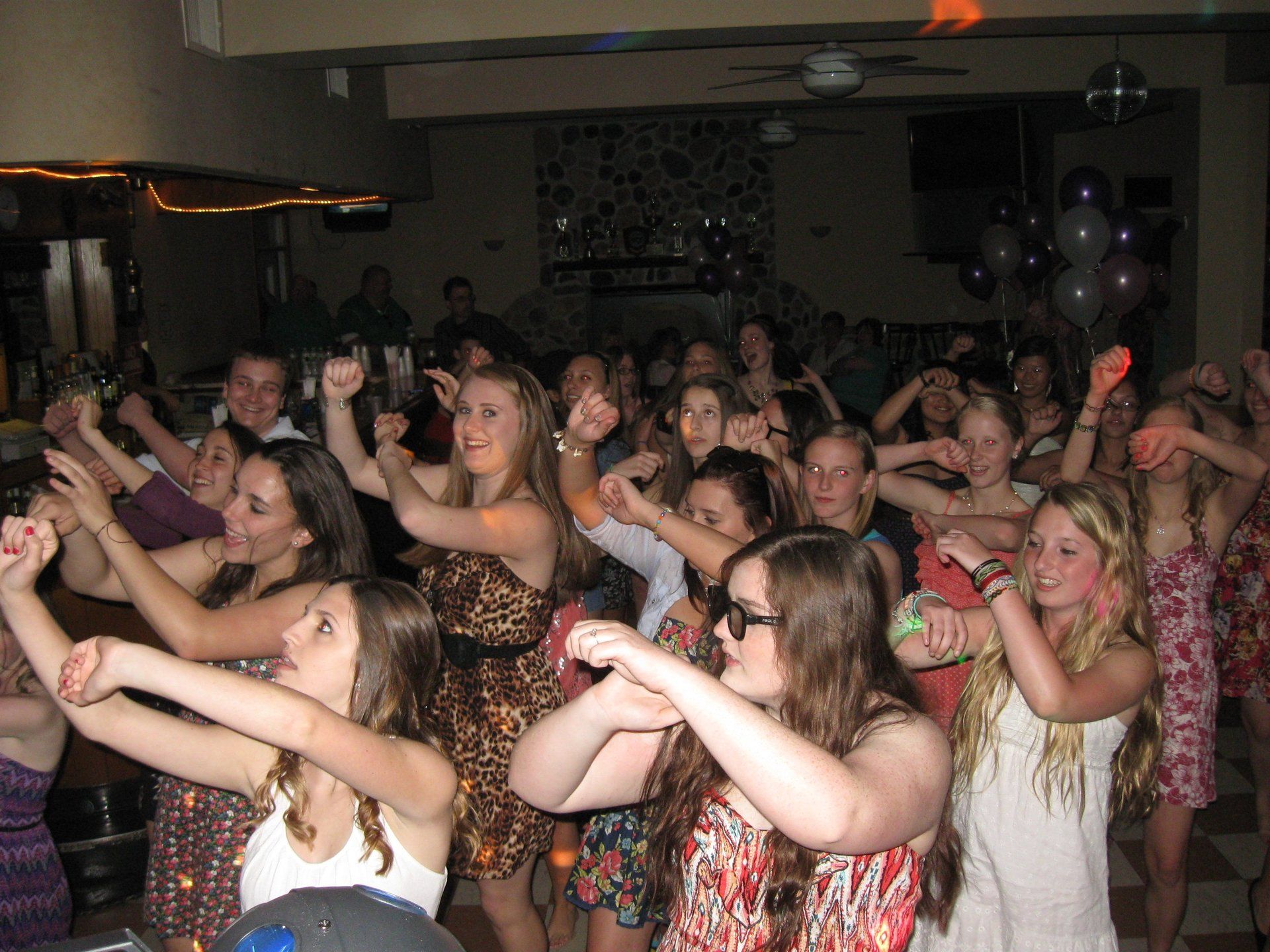 A large group of people are dancing in a room