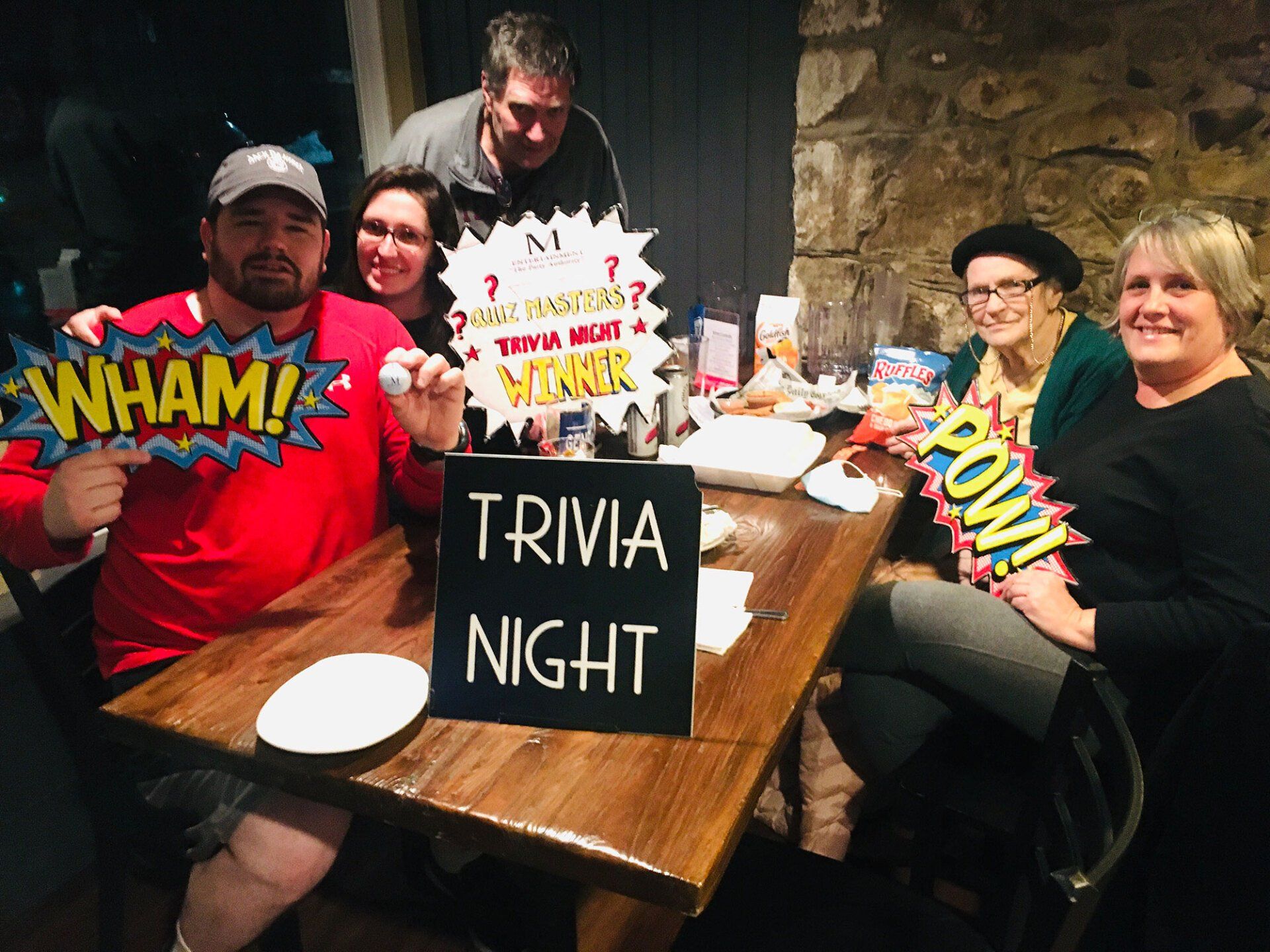 A group of people sitting at a table with a trivia night sign