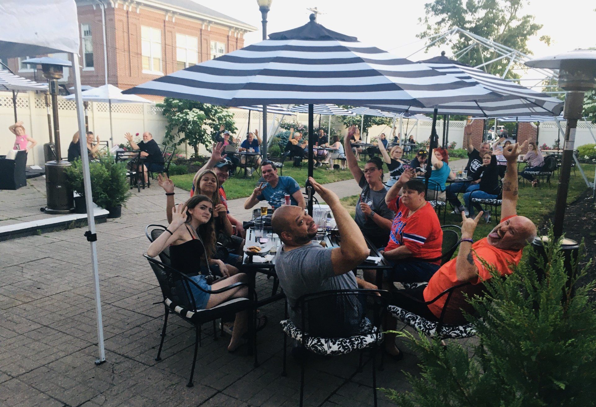 A group of people are sitting at tables under umbrellas.