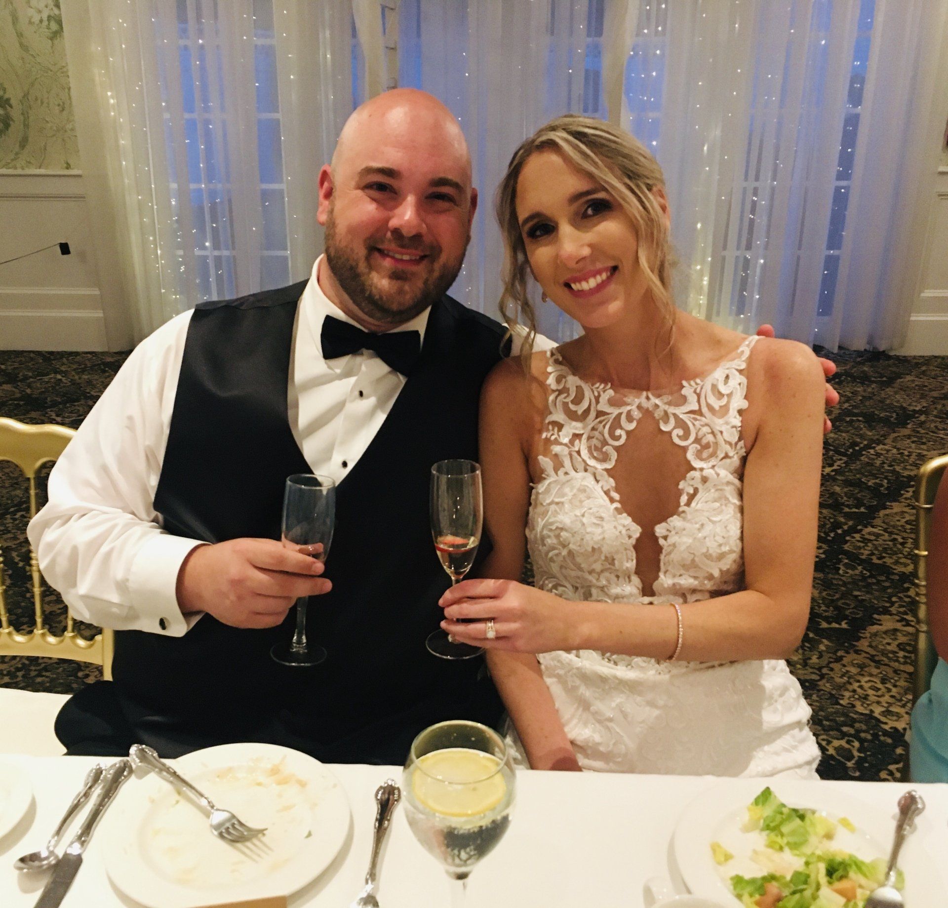 A bride and groom pose for a picture at their wedding reception