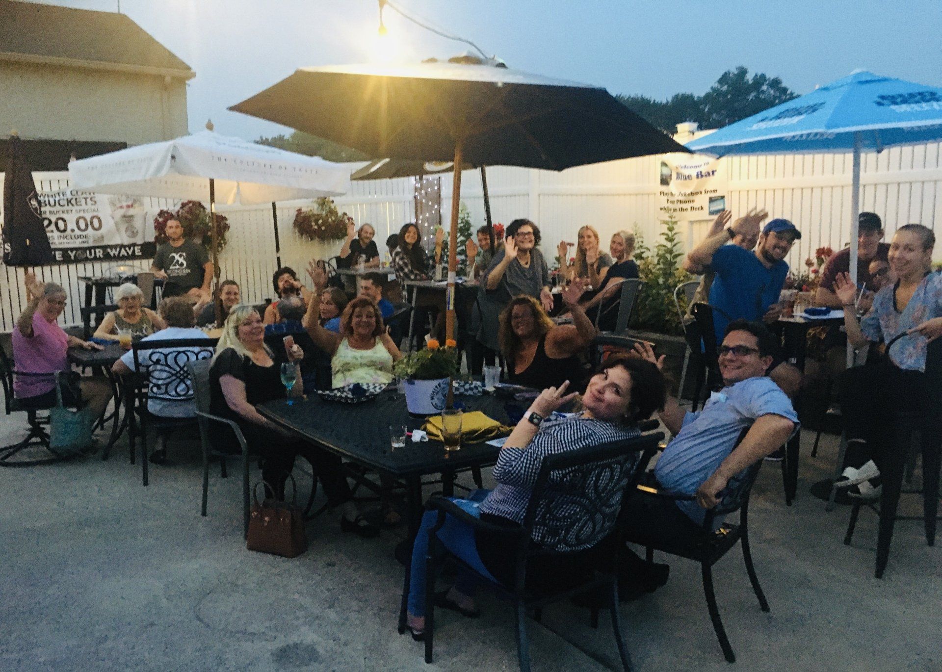 A group of people are sitting at tables under umbrellas.