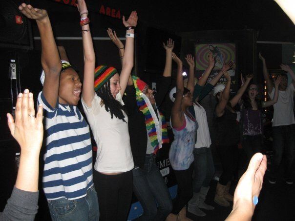 A group of people are raising their hands in the air
