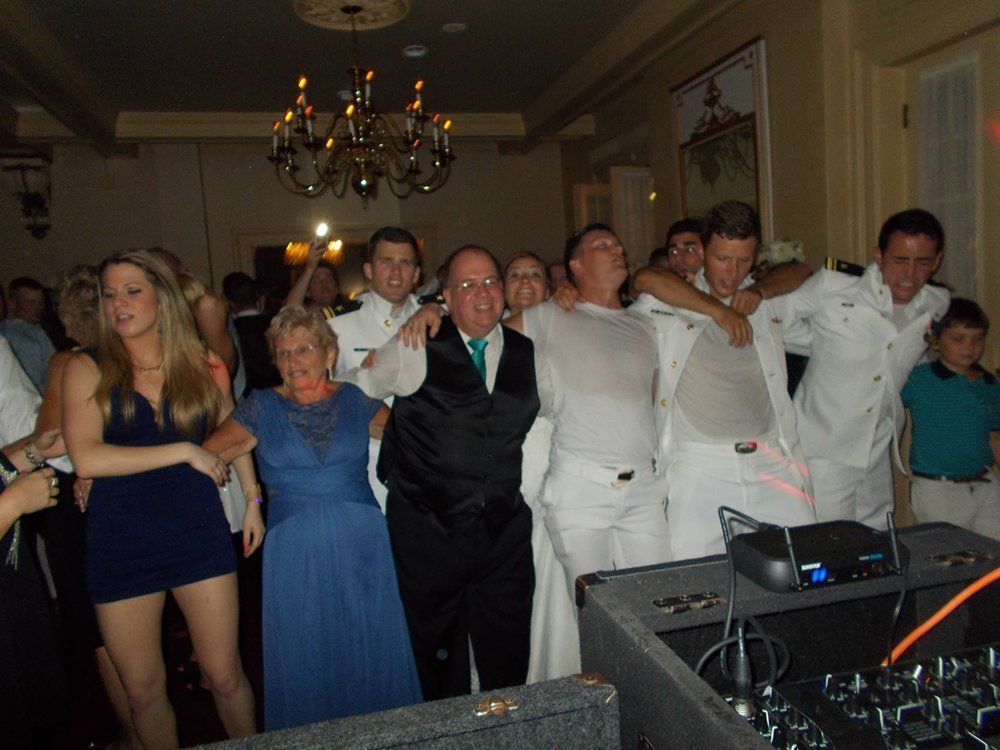 A group of people are posing for a picture at a wedding reception.