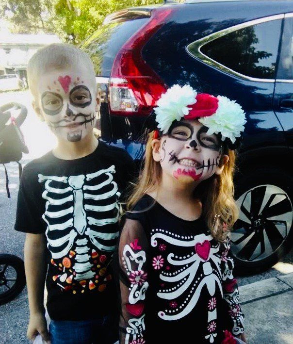 A boy and a girl are dressed up as skeletons for halloween