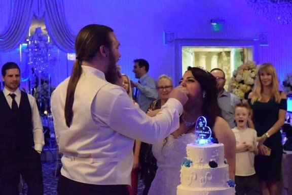 A man is feeding a woman a piece of cake at a wedding reception.