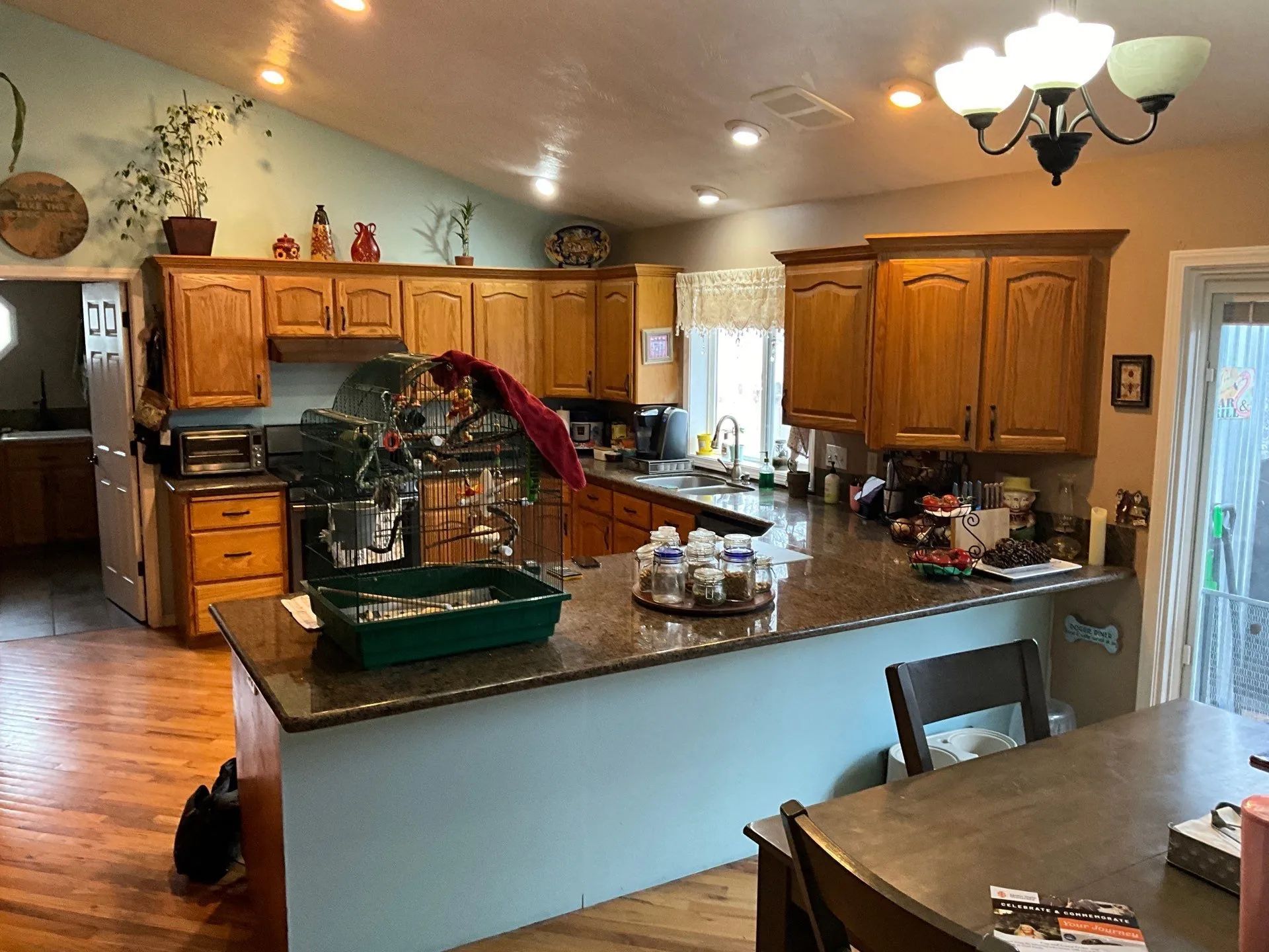 Spacious kitchen with wooden cabinets, central island, and dining table under warm ceiling lights