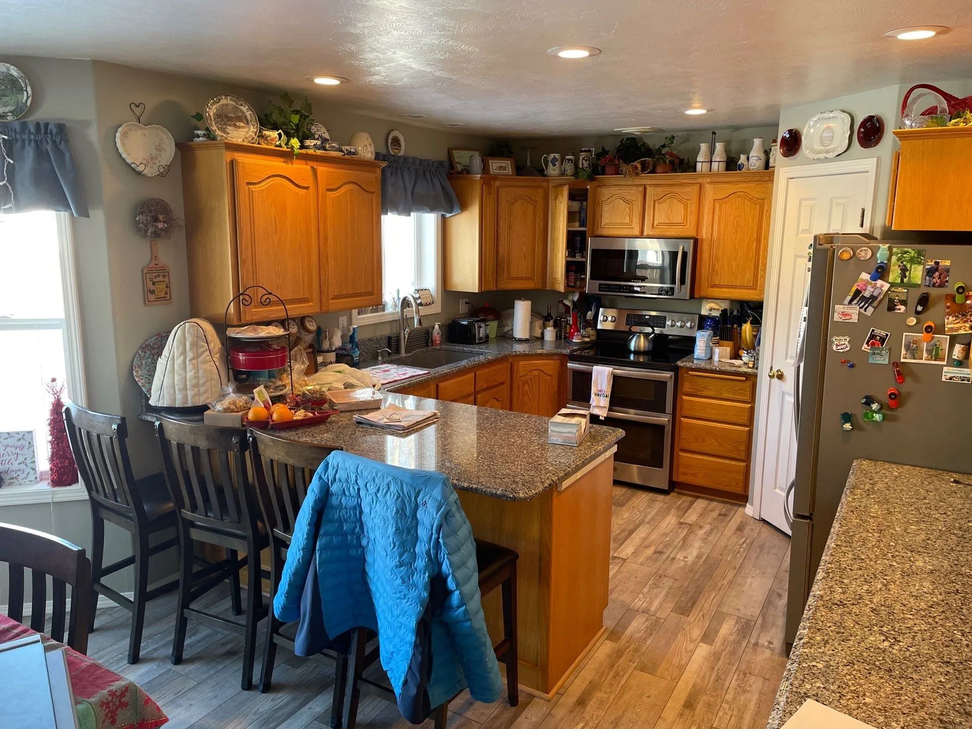 Cozy kitchen with wooden cabinets, granite island, dining table, and refrigerator covered in magnets