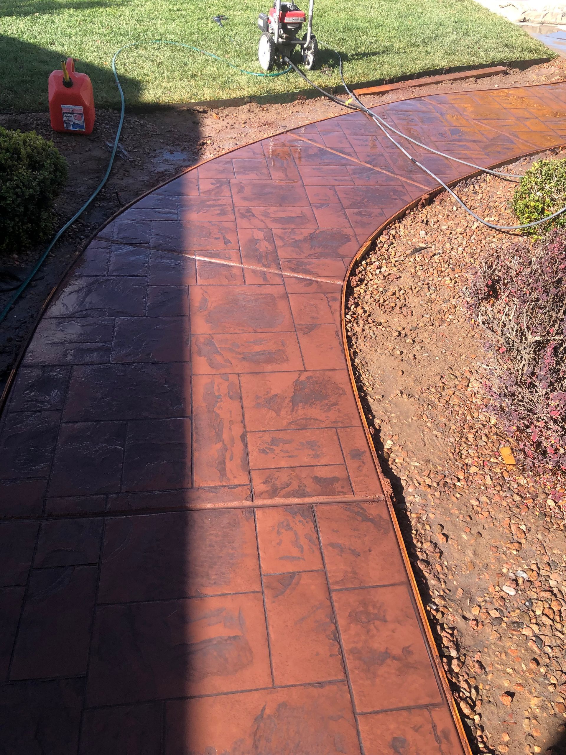 A concrete walkway with a gas can in the background.