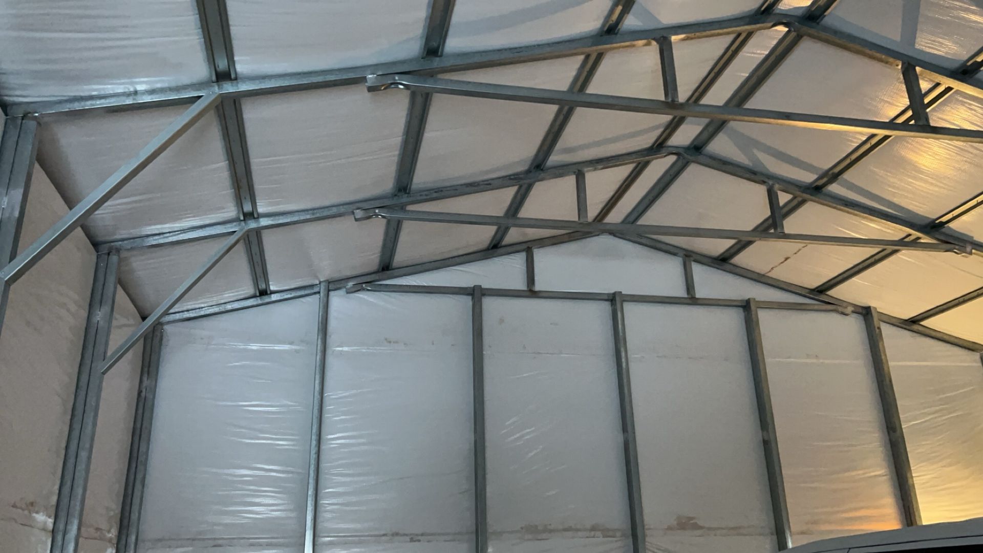 The inside of a metal building with a clear roof