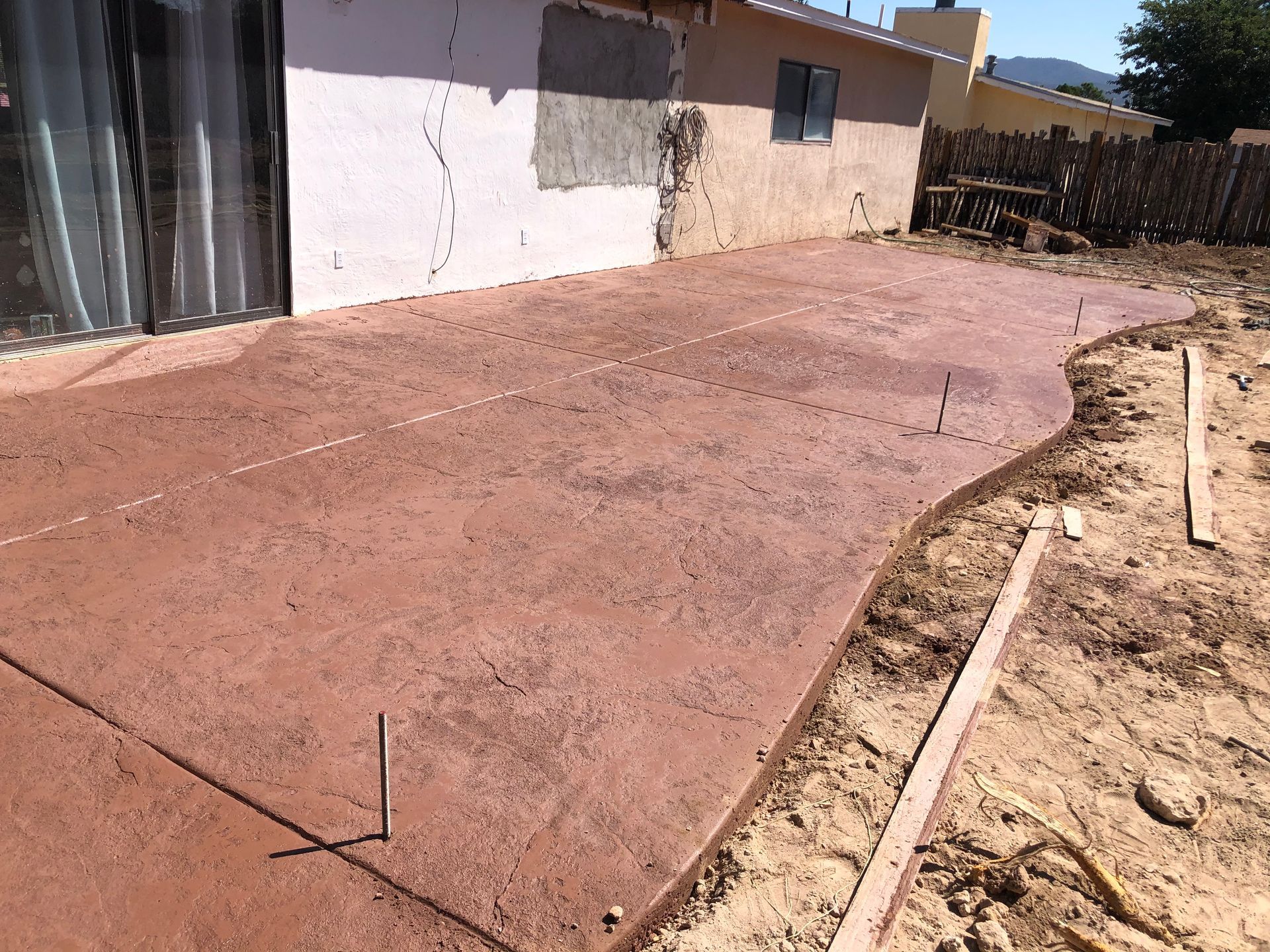 A concrete walkway is being built in front of a house
