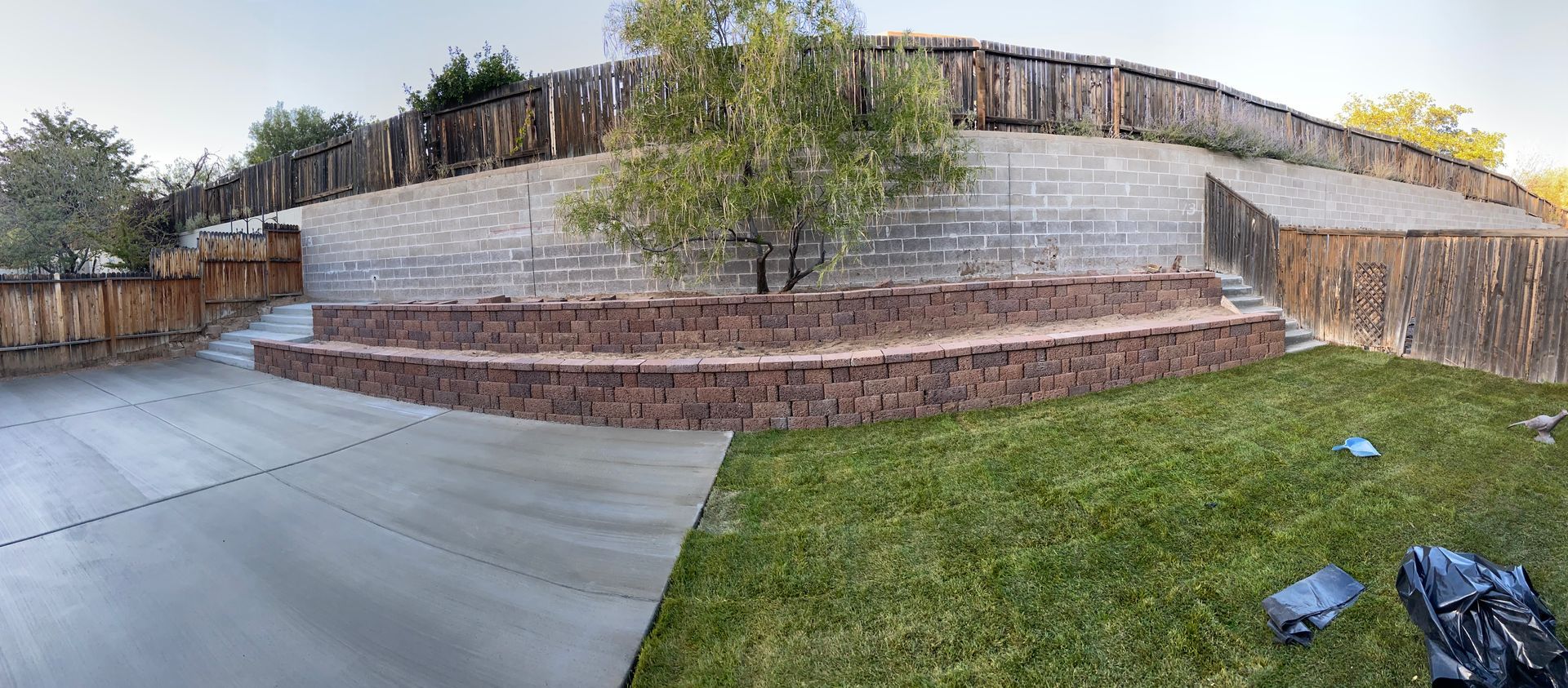 There is a large brick wall in the backyard of a house.