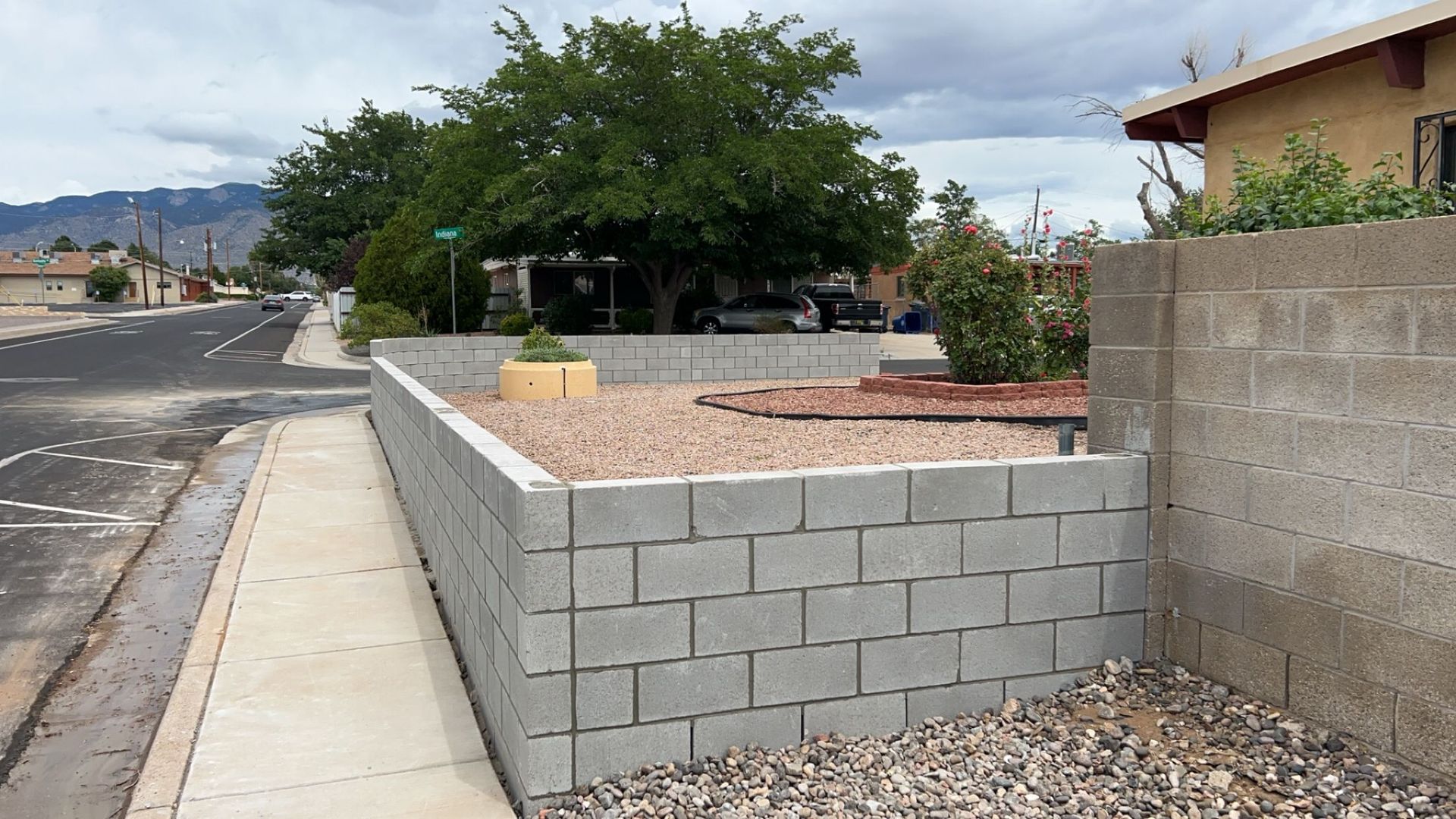 A brick wall is being built in front of a house