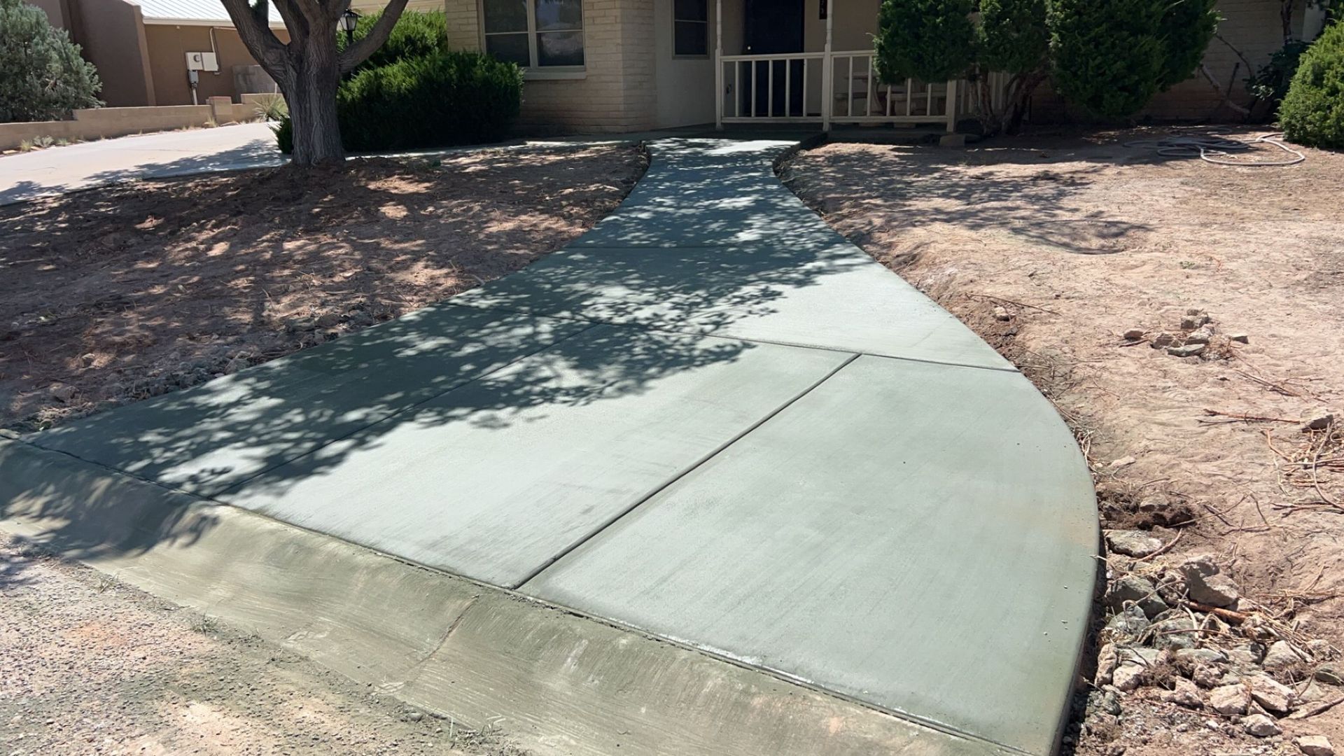 A concrete walkway is being built in front of a house.