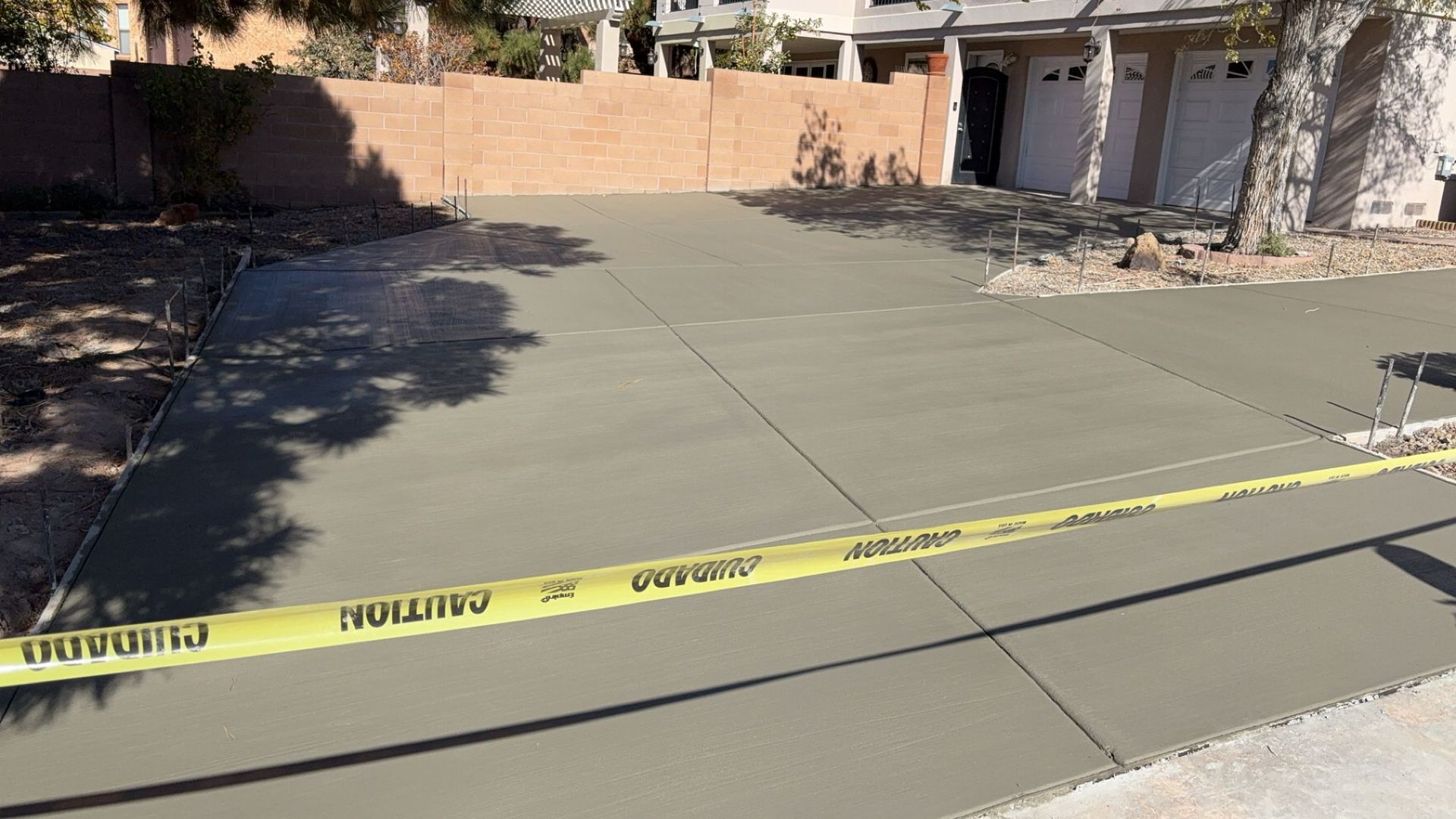 A concrete driveway is being built in front of a house.