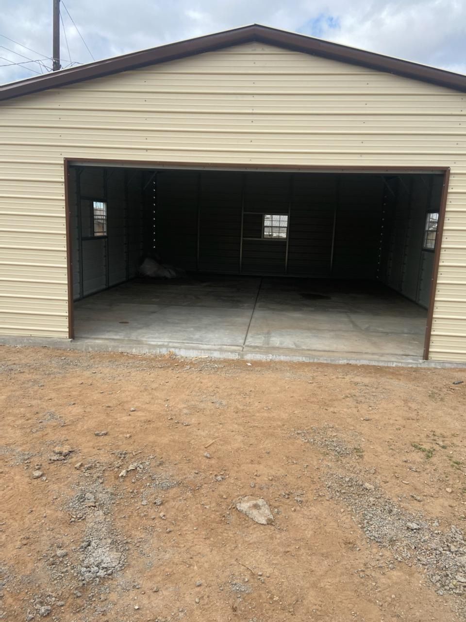 A garage with the door open and a concrete floor.