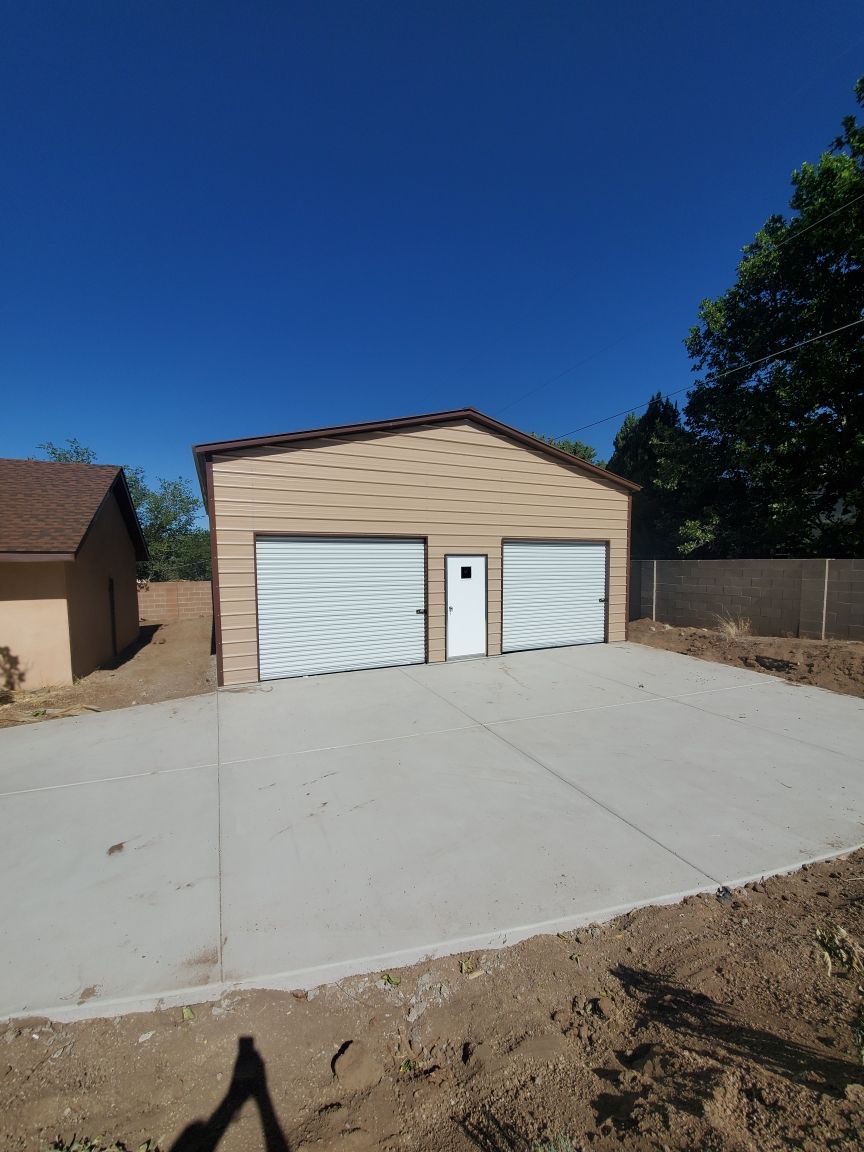 A garage with two garage doors and a concrete driveway