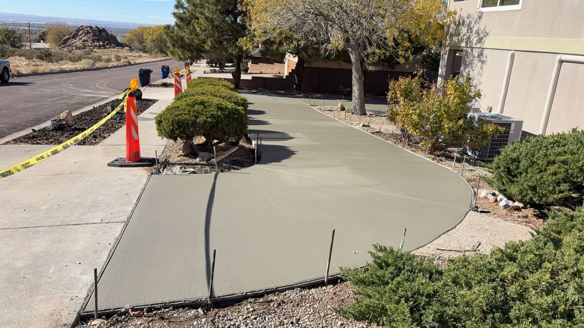 A concrete walkway is being built in front of a house.