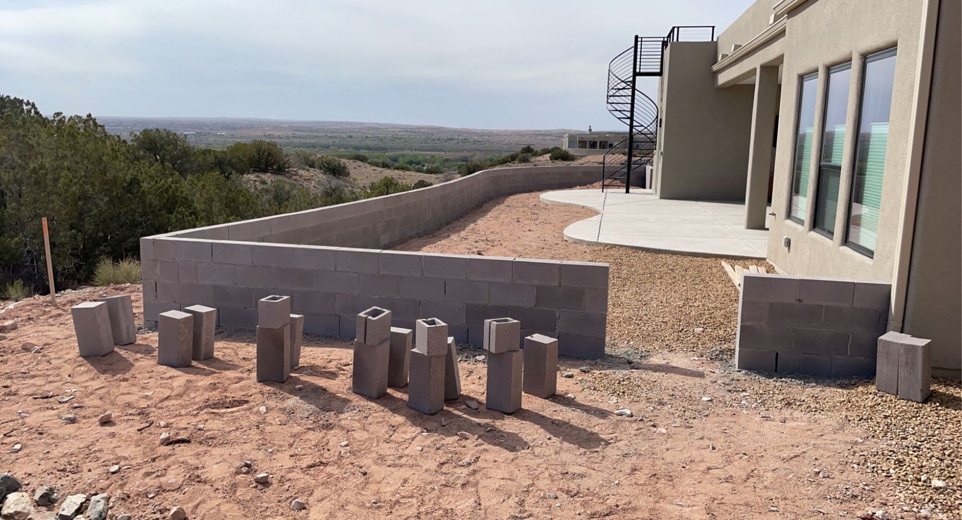 A brick wall is being built in front of a house.