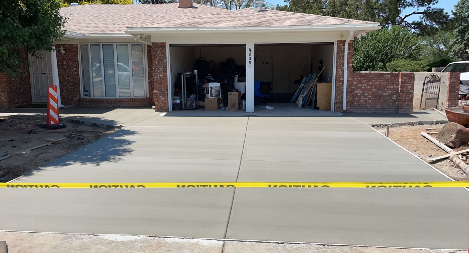 A concrete driveway is being built in front of a house.