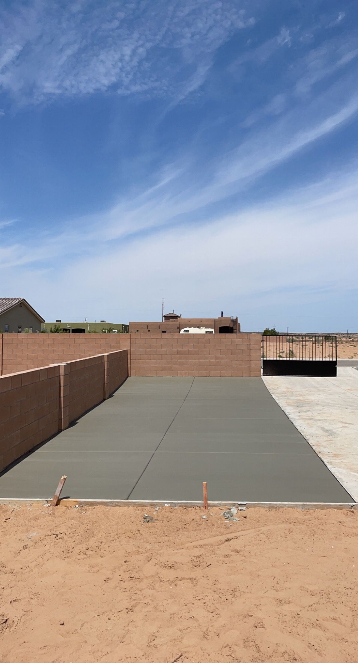 A concrete driveway is being built in the backyard of a house.