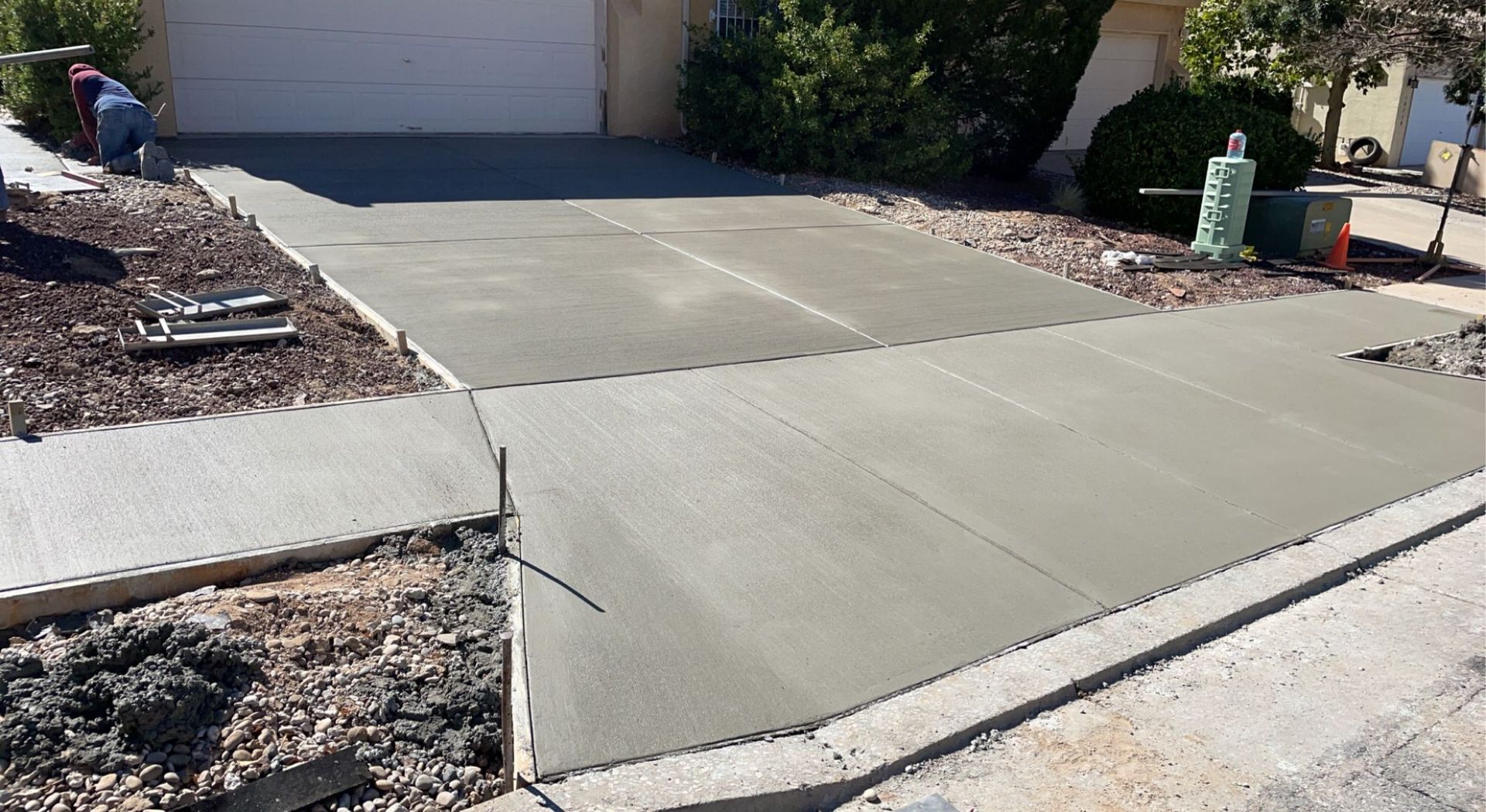 A concrete driveway is being built in front of a house.