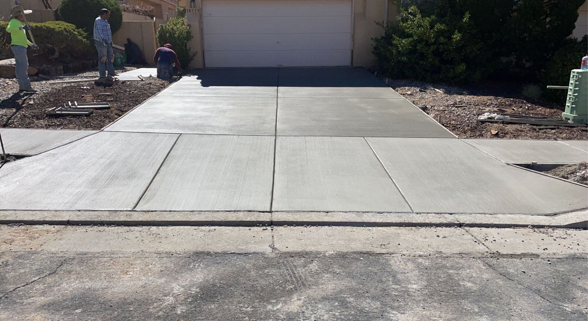 A concrete driveway is being built in front of a house.