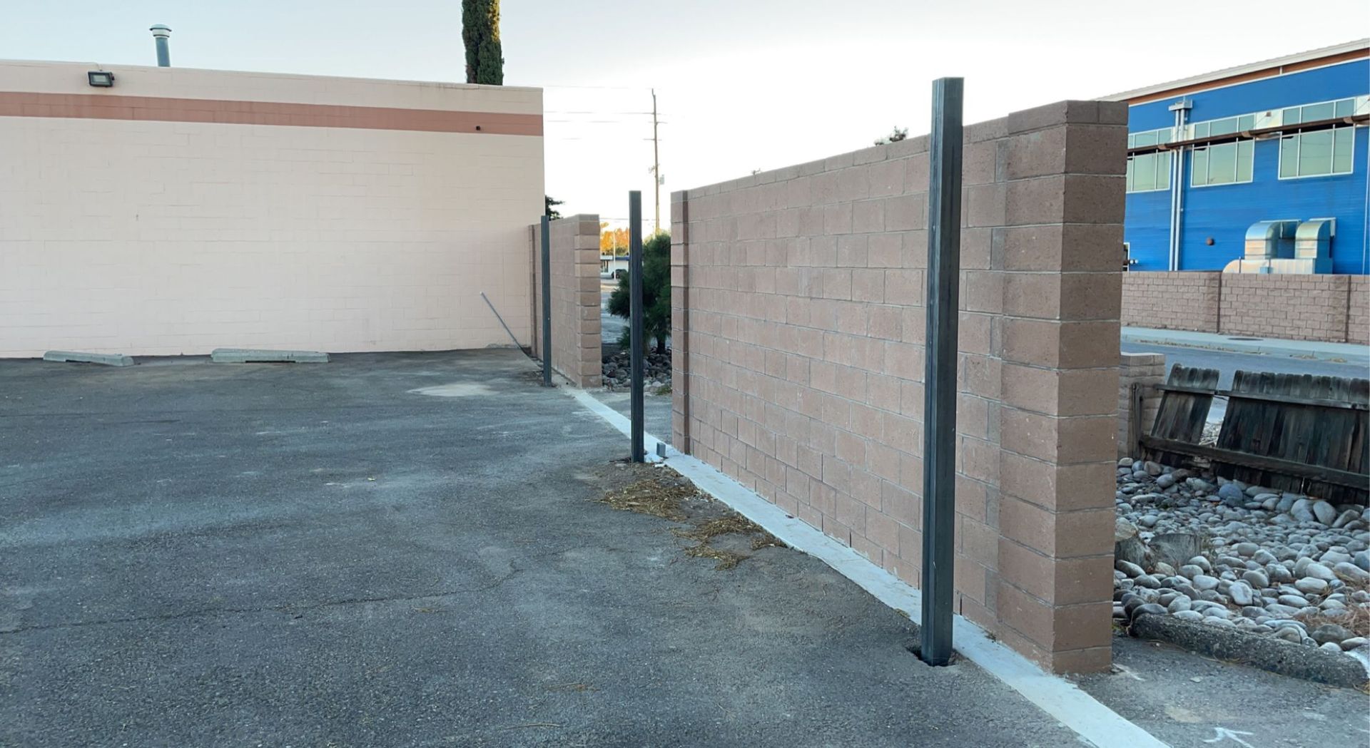 A brick fence is being built in front of a building.