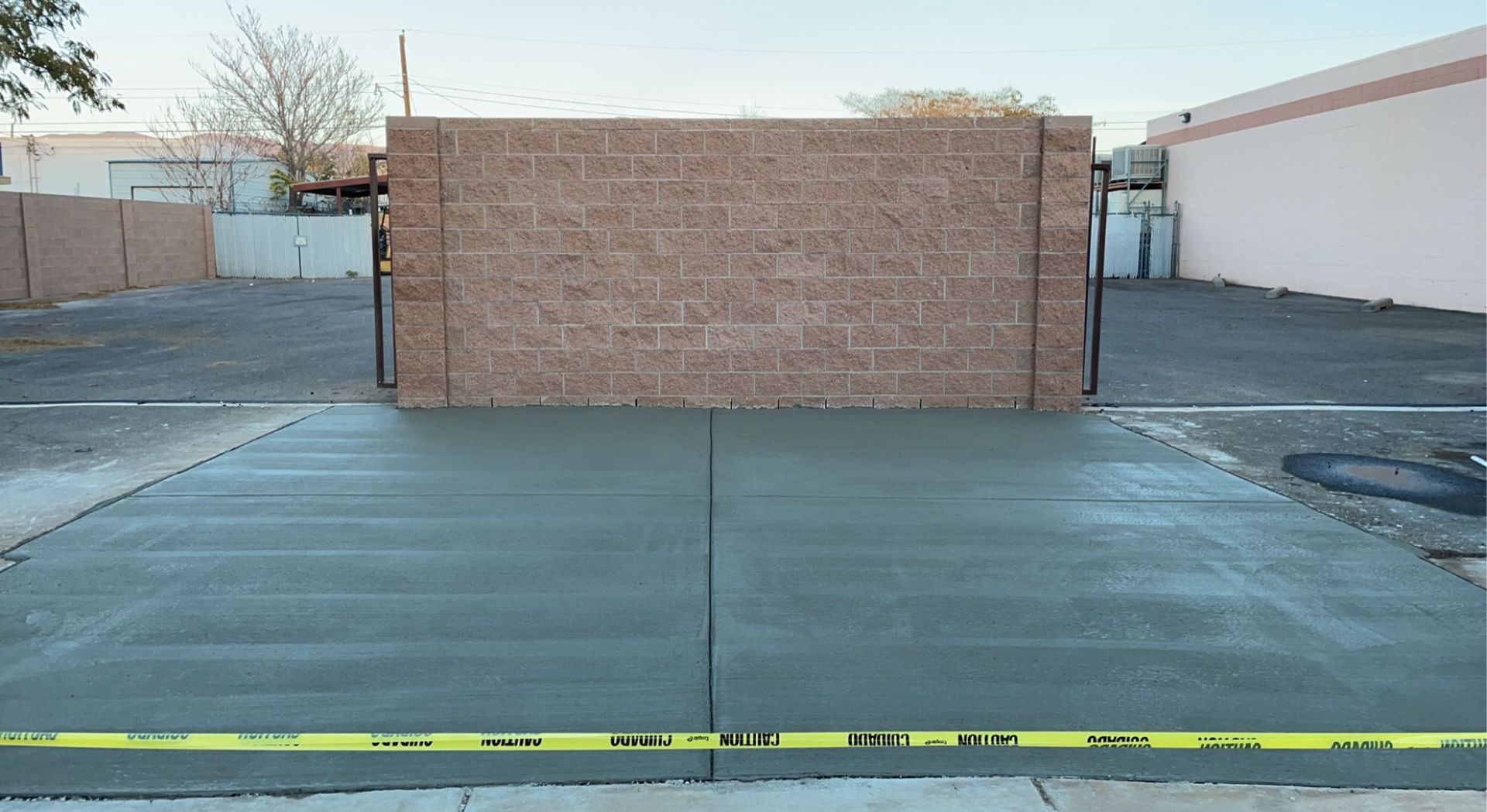 A concrete driveway with a brick wall in the background.