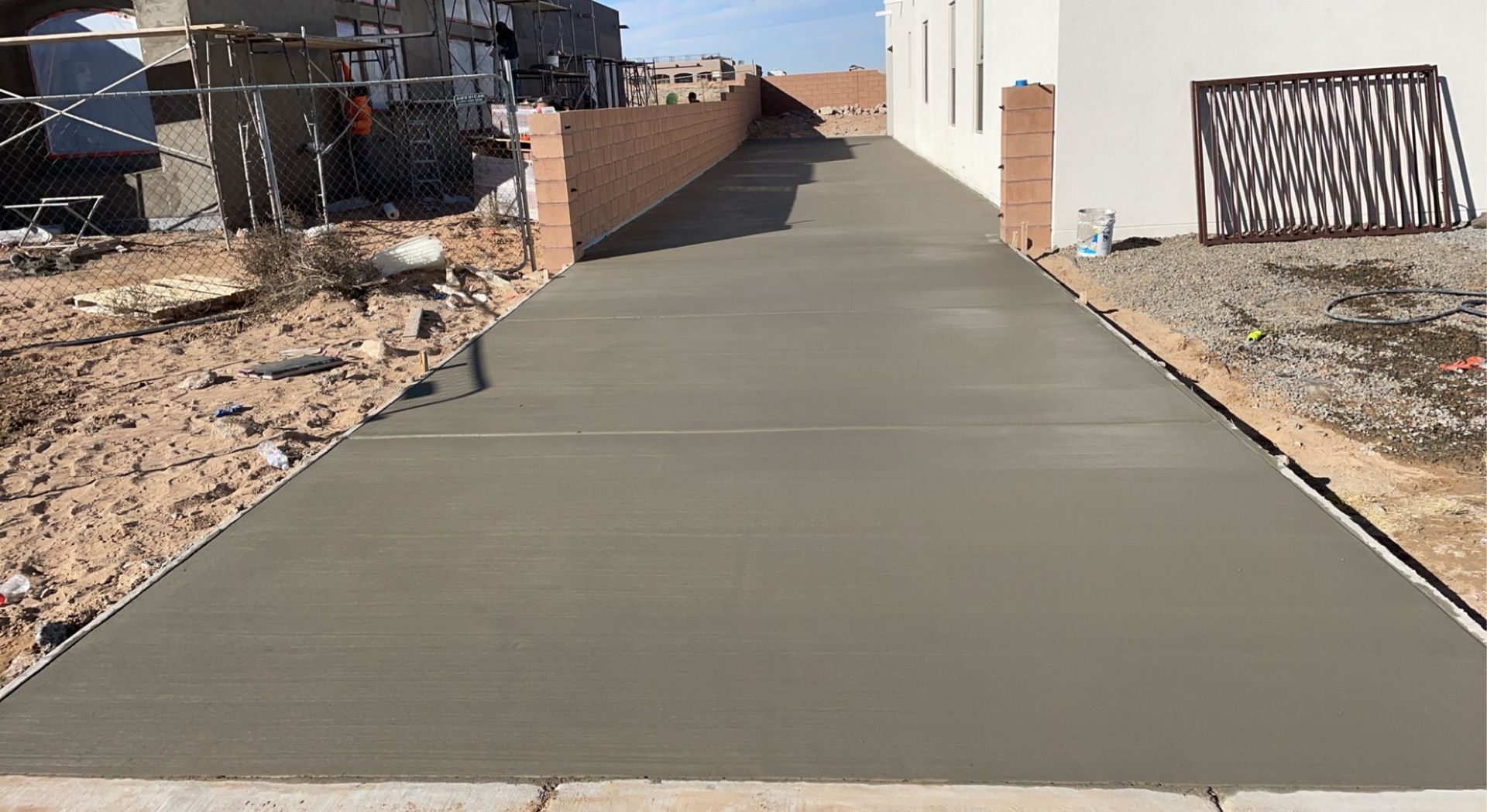 A concrete driveway is being built in front of a house.
