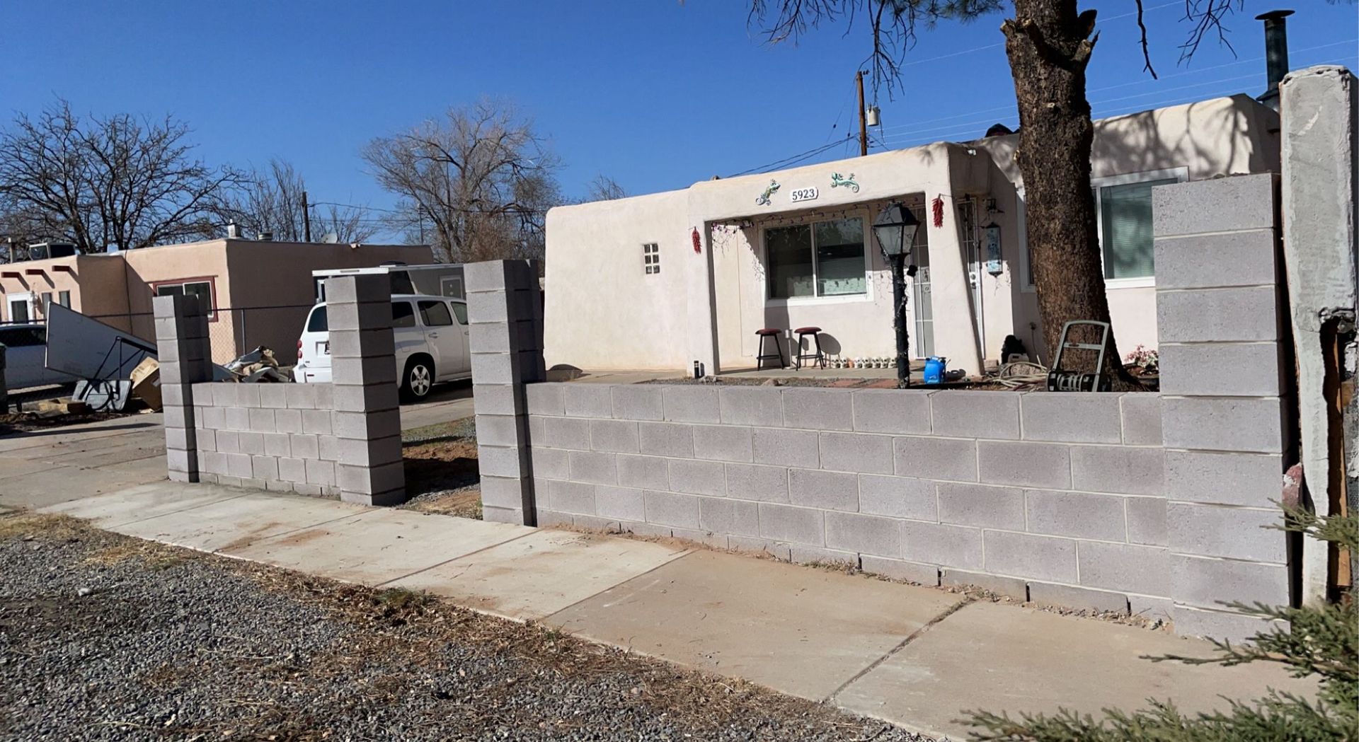 A brick wall is being built in front of a house.