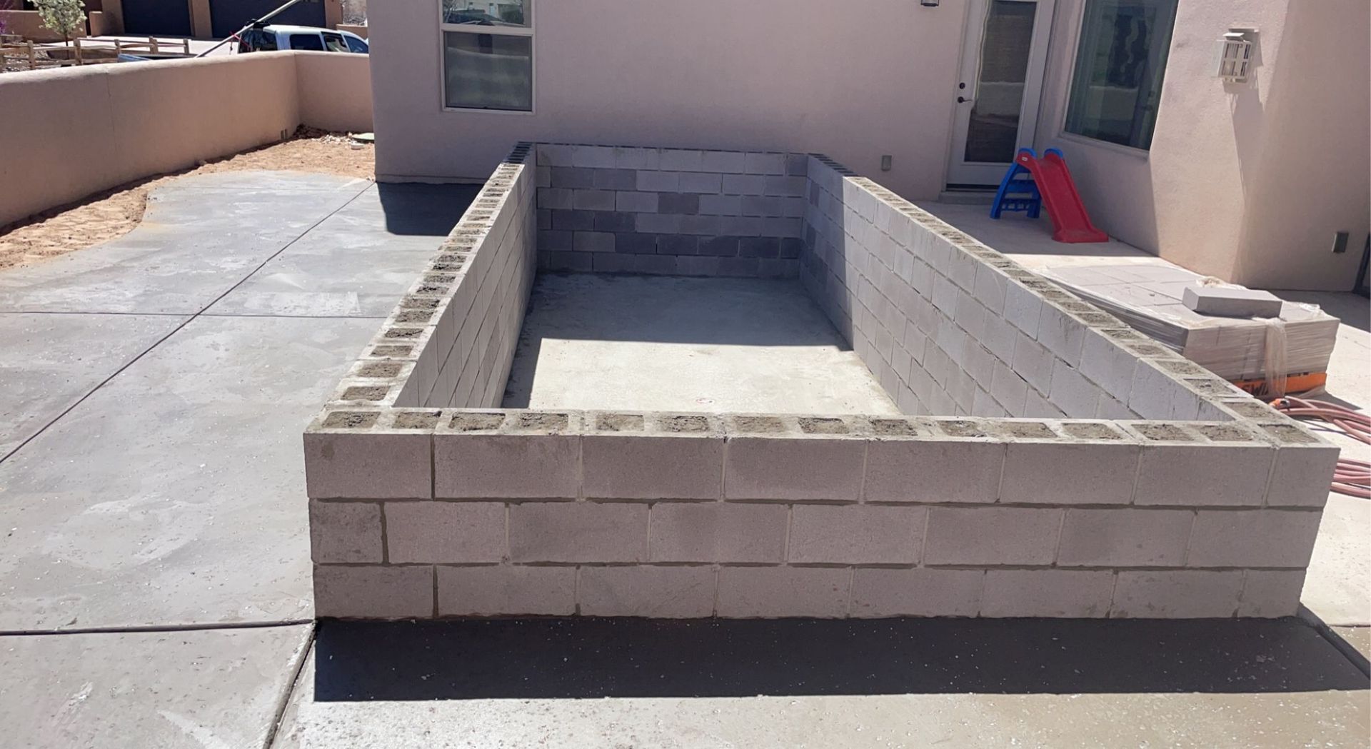 A brick wall is being built in front of a house
