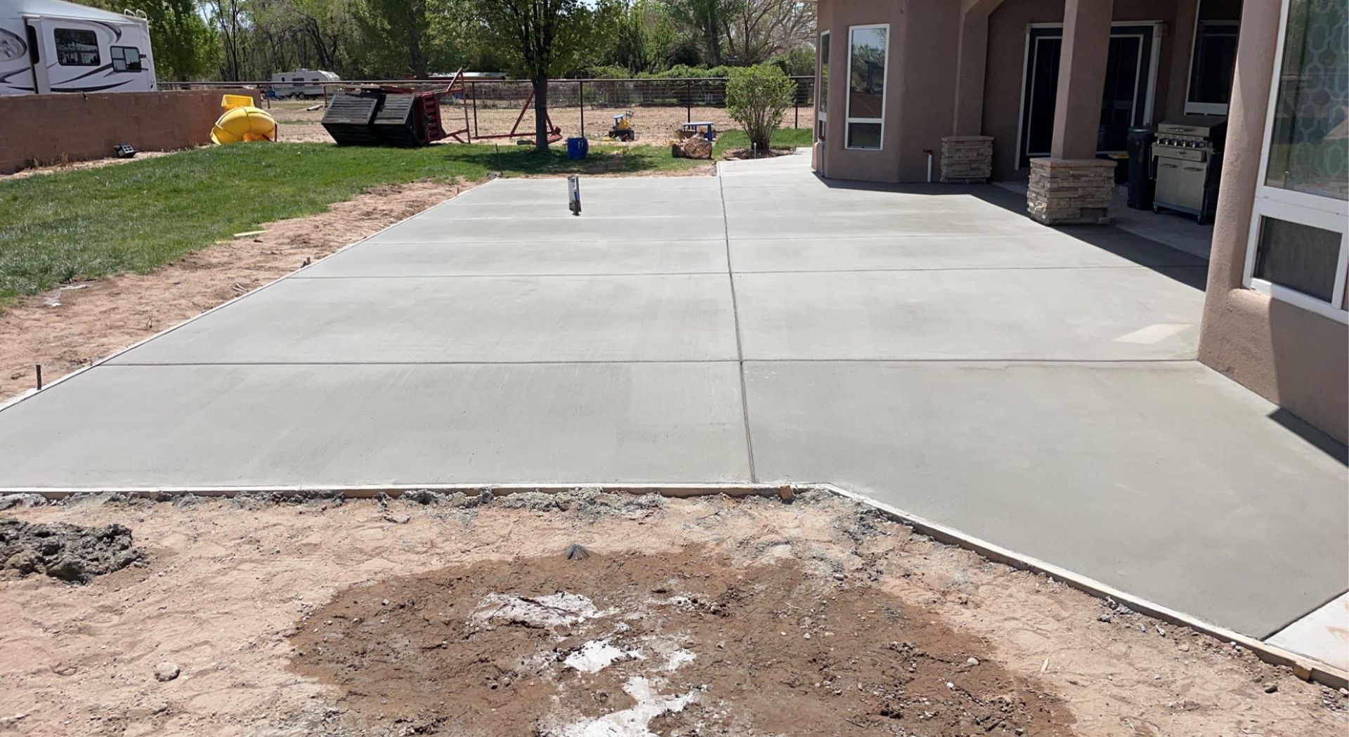A concrete driveway is being built in front of a house.