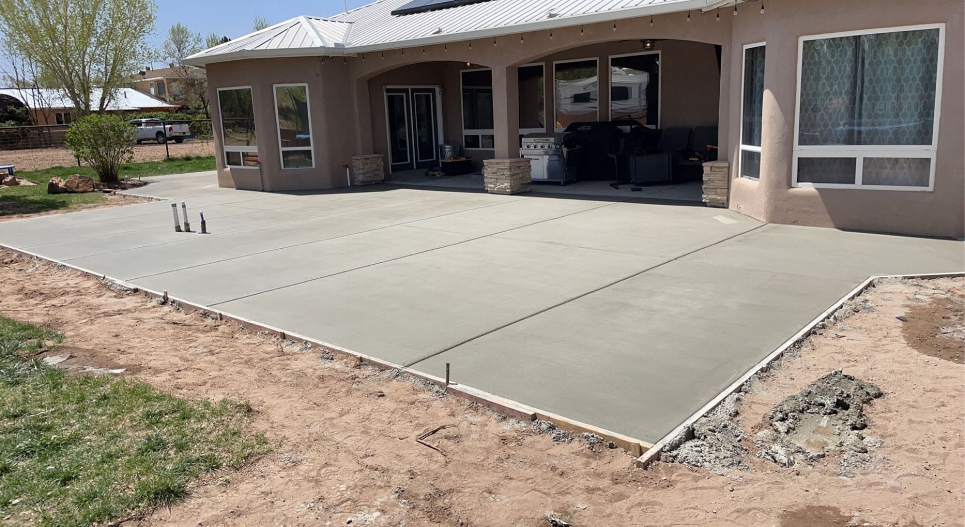 A concrete driveway is being built in front of a house.