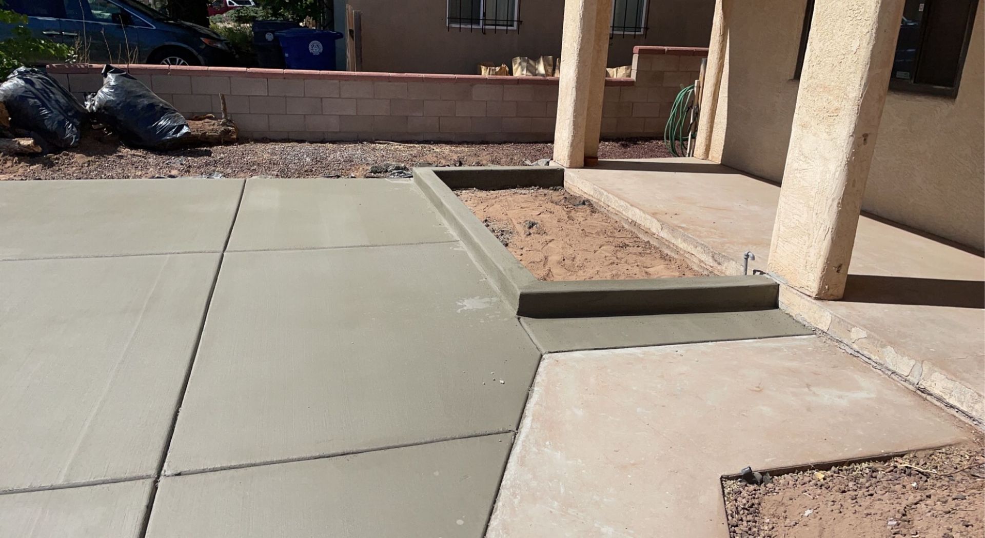 A concrete patio is being built in front of a house.
