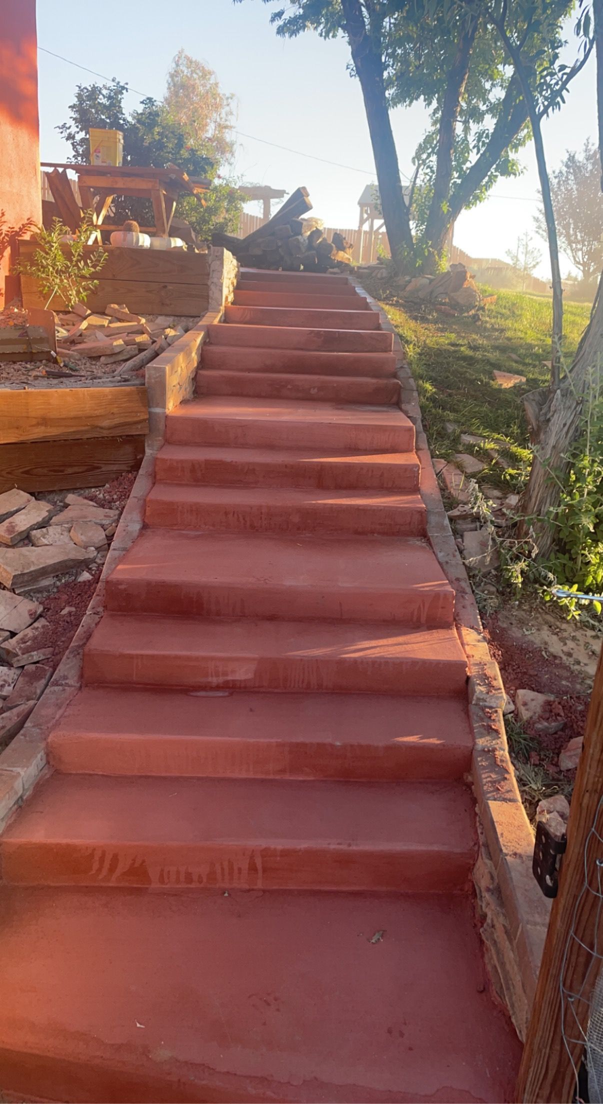 A set of red concrete stairs leading up to a house.
