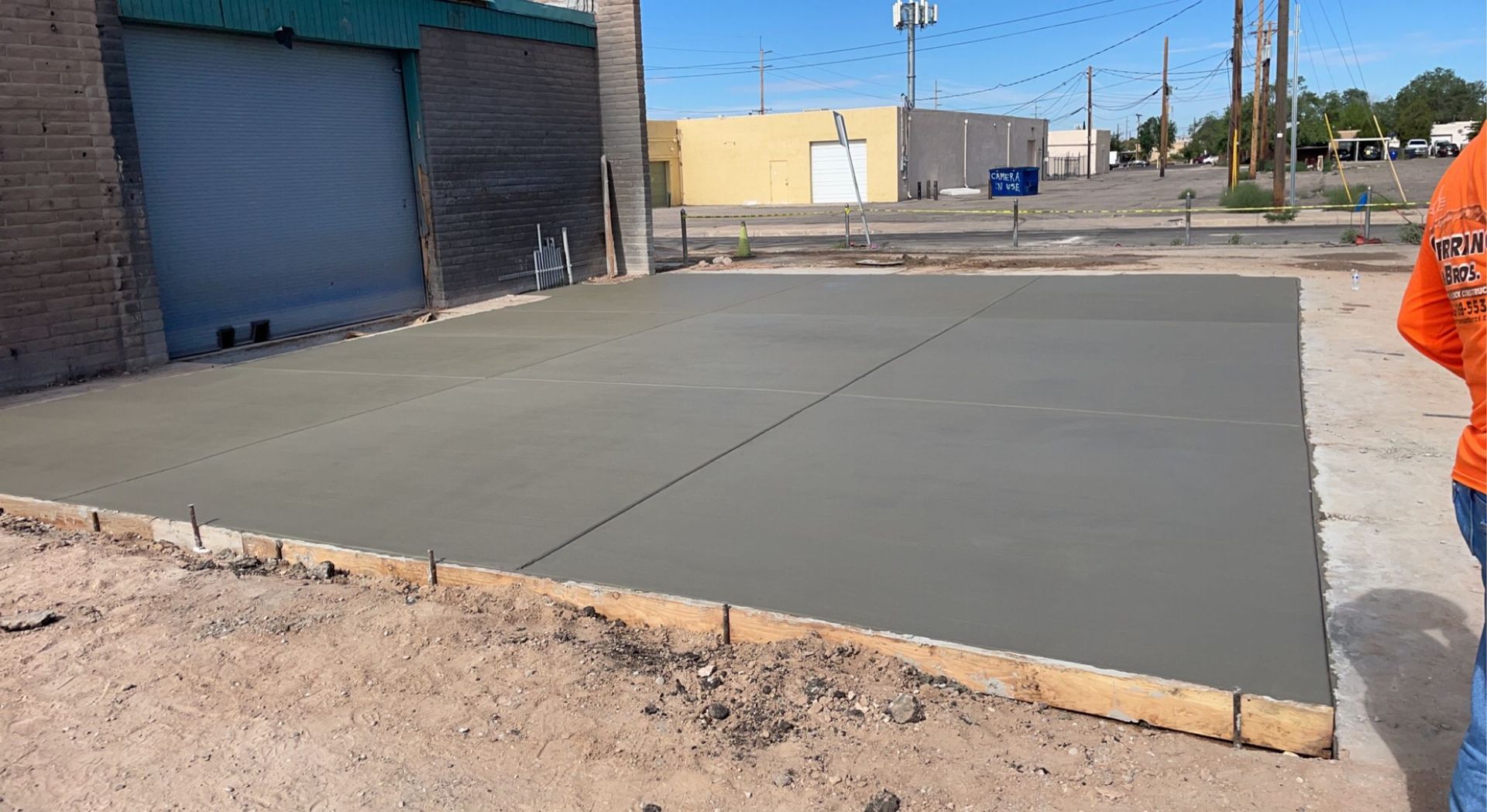 A man is standing on a concrete slab in front of a building.