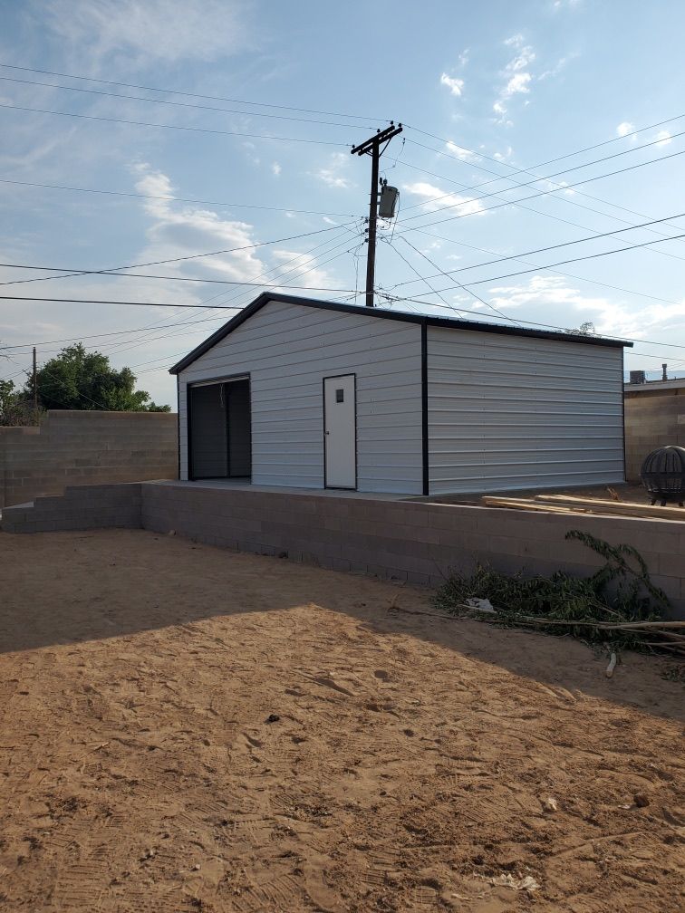 A white garage with a door and a telephone pole in the background