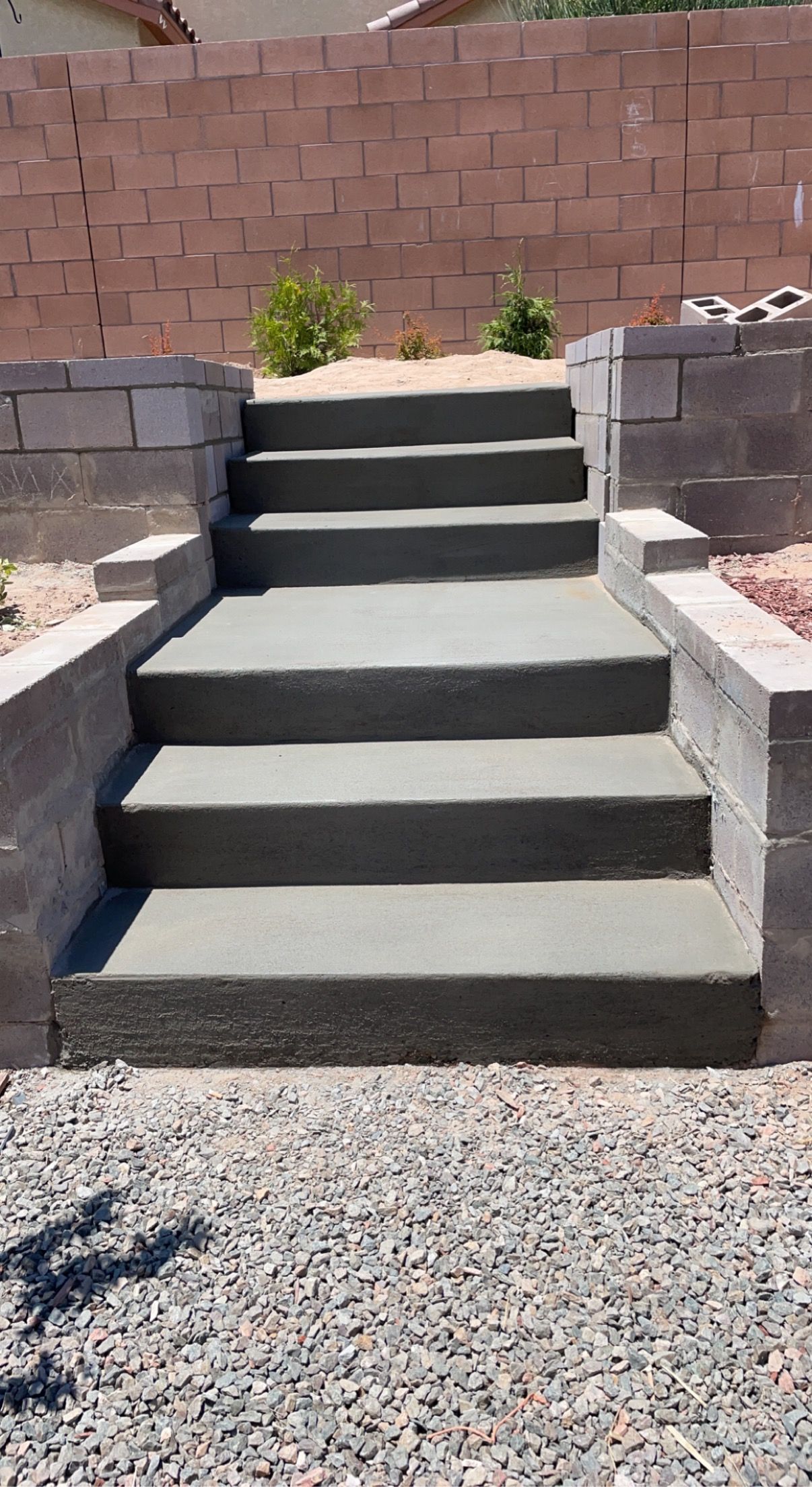 A set of concrete stairs leading up to a brick wall.