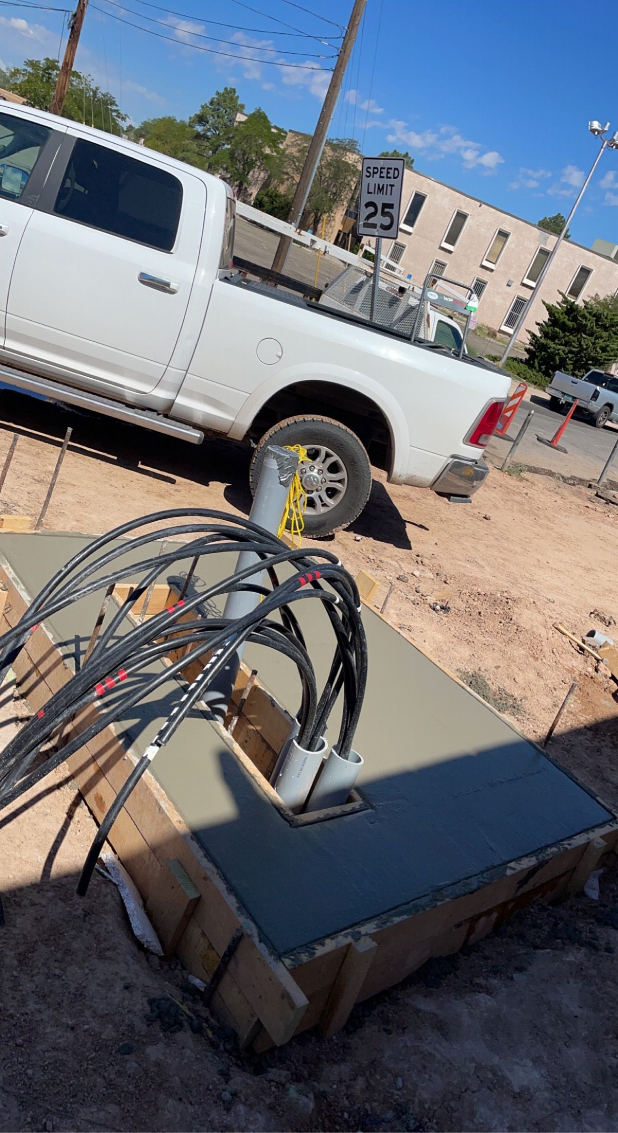 A white truck is parked on the side of the road next to a pile of wires.