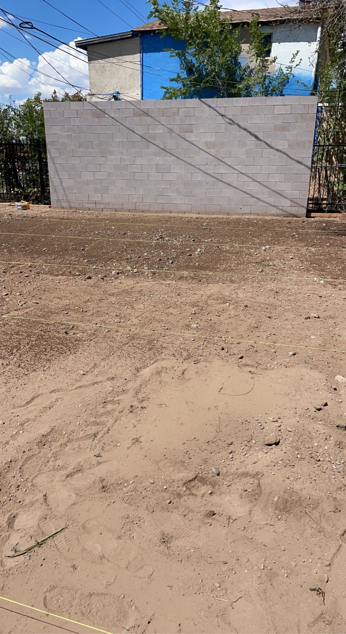 A dirt field with a blue building in the background.